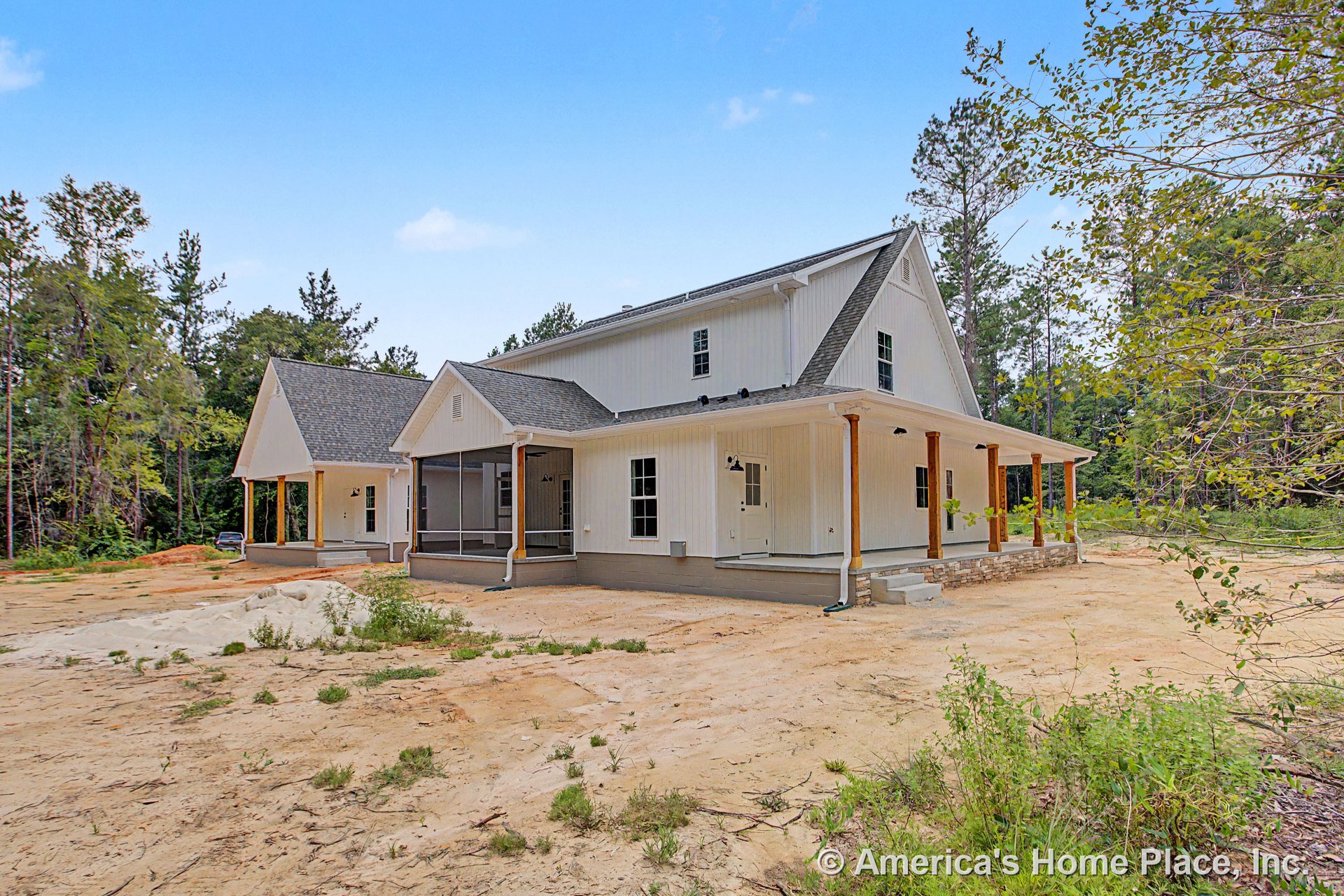White board and batten siding exterior with a spacious covered porch featuring wood columns, a screened section, multiple exterior doors, black outdoor lighting fixtures, and stone