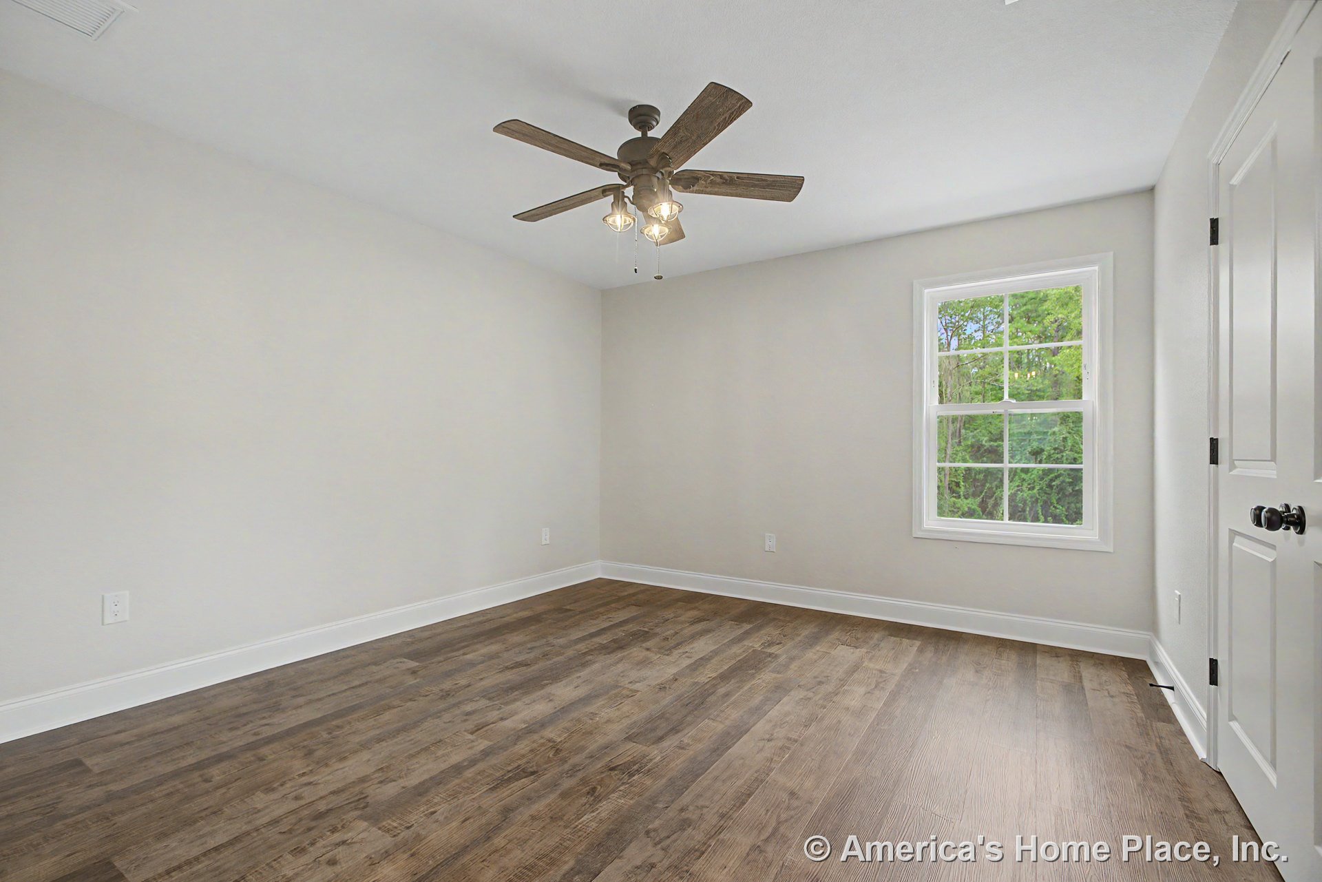 Bedroom with wood-look plank flooring, neutral walls, white baseboards, ceiling fan and light fixture, single window framed in white trim, and paneled door featuring black