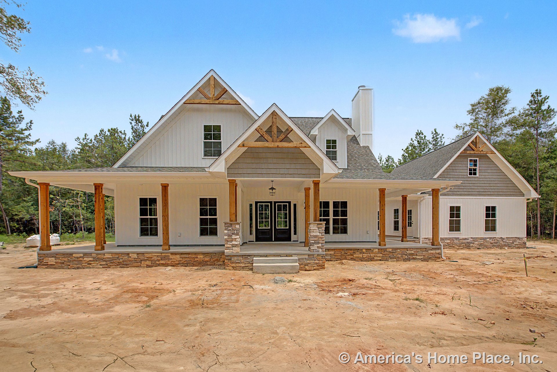 Large covered front porch with stone column bases and wood support beams, board and batten siding, multiple gabled roofs, double front doors, decorative trim, windows, permanent