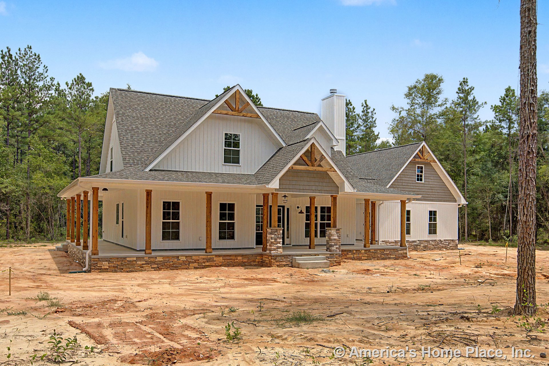 Large covered front porch with wooden columns on stone bases, board and batten siding, stone trim foundation, gable roof with architectural shingles, multiple double-hung windows