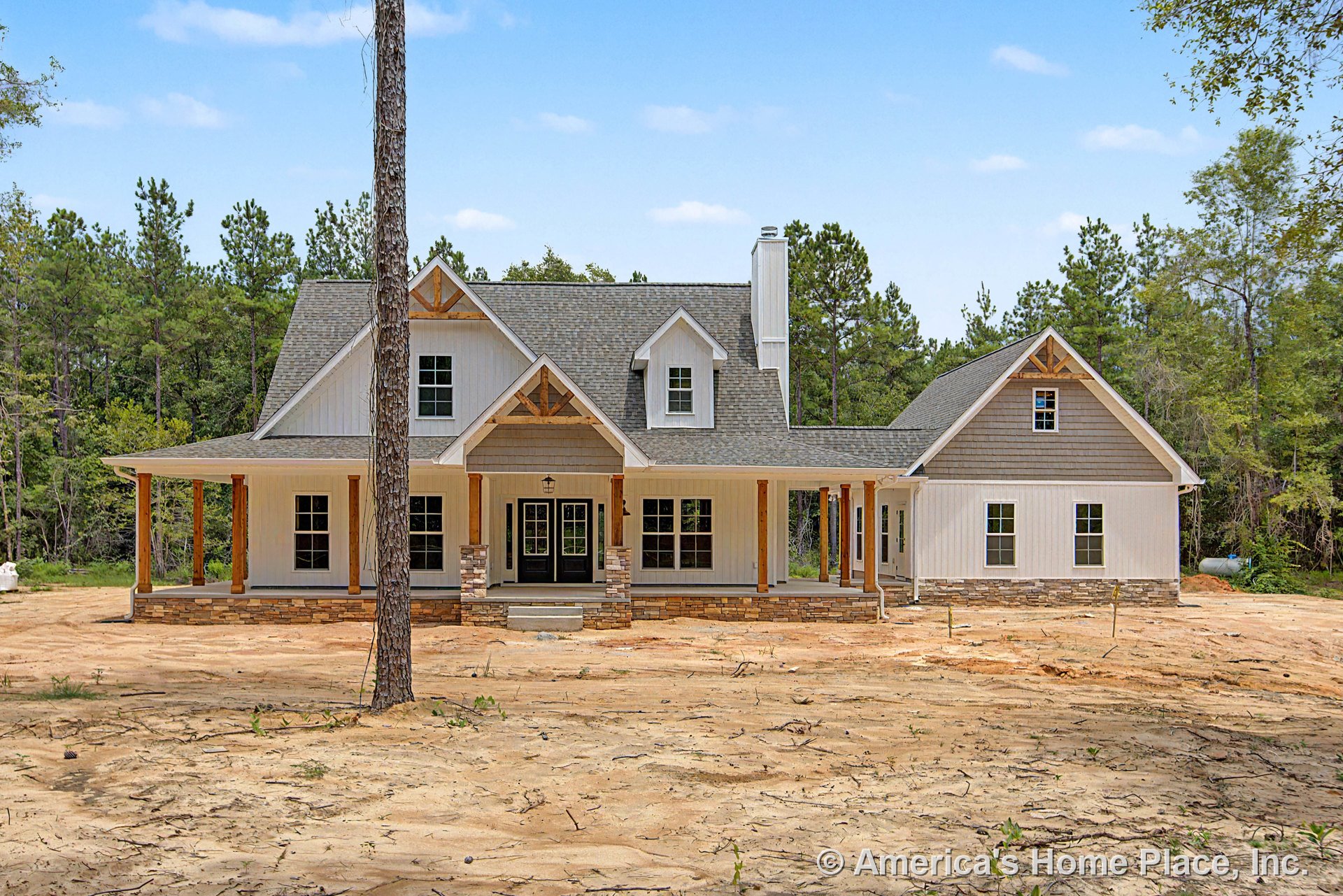 Large covered front porch with stone column bases, wood beams and trim, board and batten siding, multiple dormer windows, and double front doors.