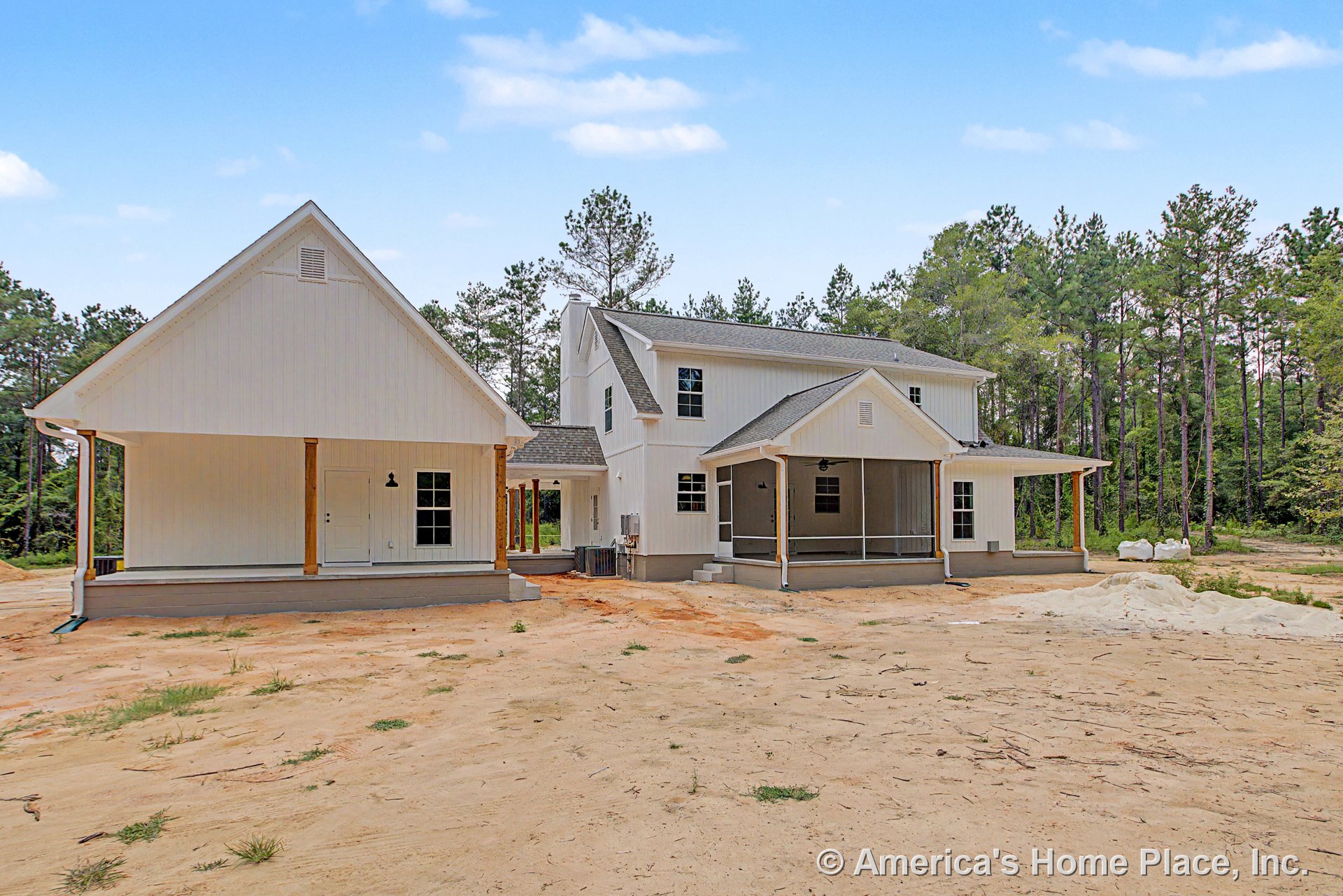 White board and batten siding with covered front and side porches supported by wood columns, multiple gable rooflines, exterior ceiling fan, double-hung windows, and detailed trim