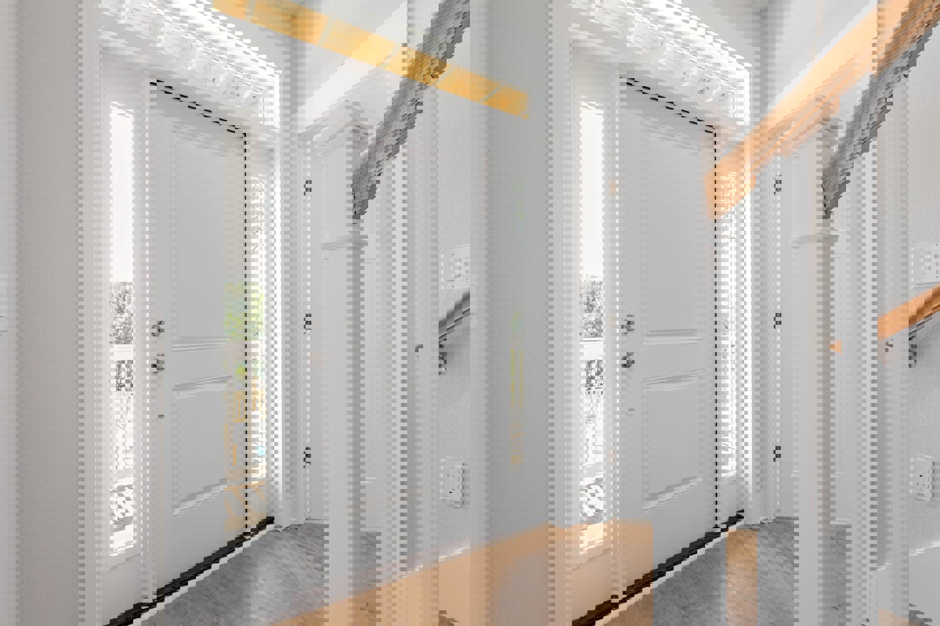 White paneled door with brushed metal handle, white wall with electrical outlet and light switch, wood flooring, crown molding