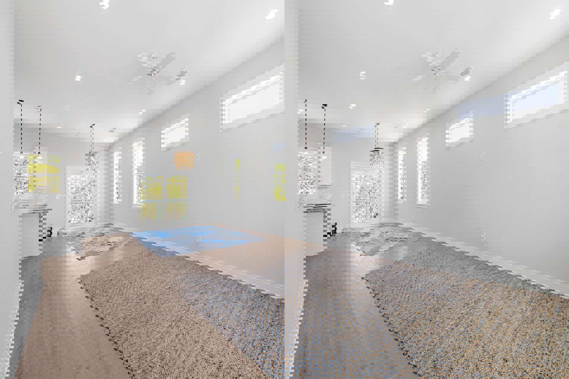 Carpeted room with ceiling fan, crystal chandelier, white sliding glass door leading to a balcony with railing, large window overlooking trees, neutral walls, and rug on the floor