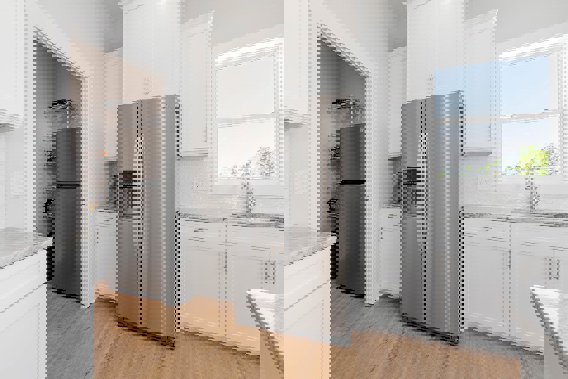 Stainless steel double-door refrigerator beside white shaker cabinets, undermount sink beneath window with tree view, chrome faucet, black and yellow storage box on open shelf