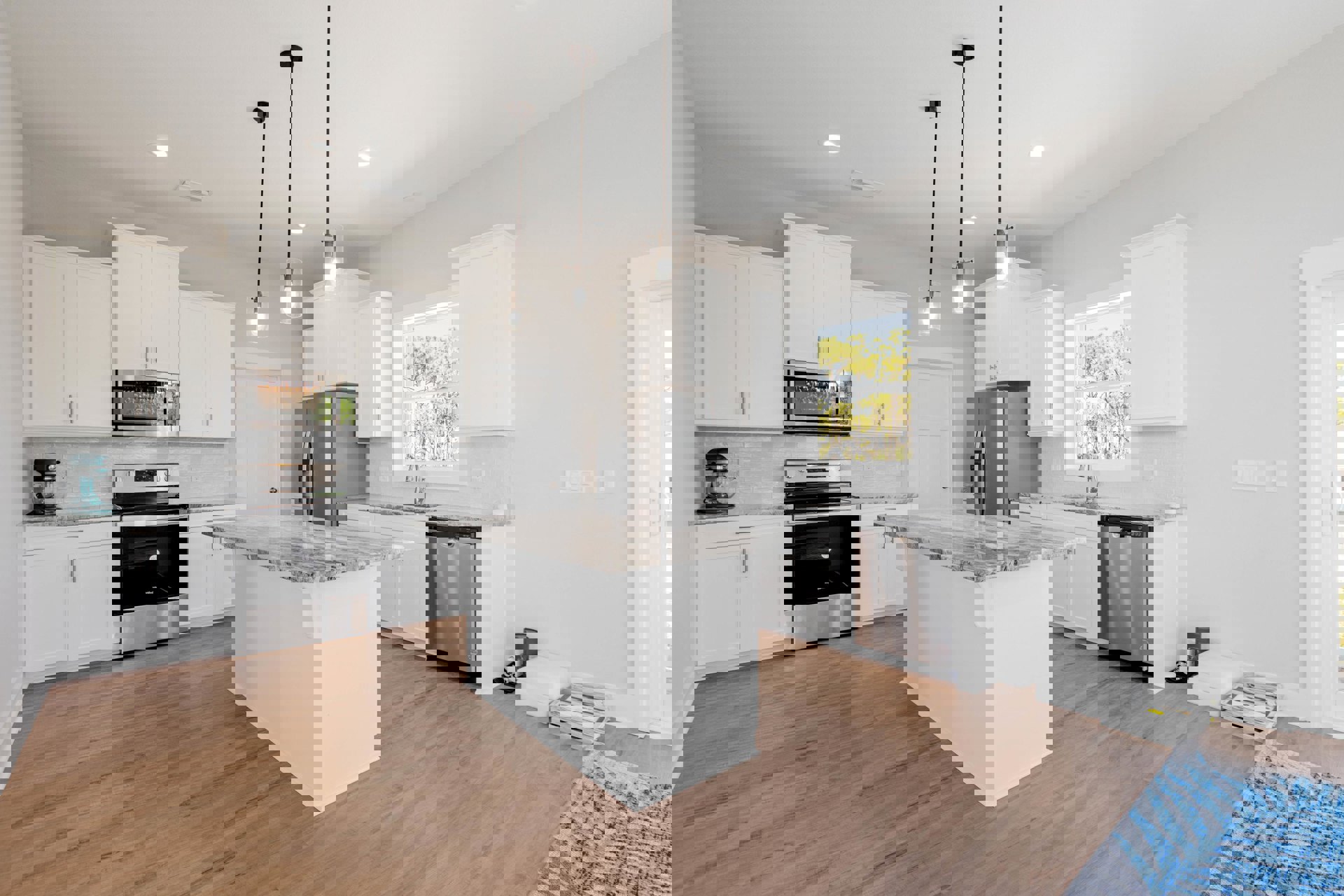 White cabinetry and marble countertops in a kitchen with a central island, stainless steel stove and dishwasher, blue and white rug on wood flooring, and modern fixtures.