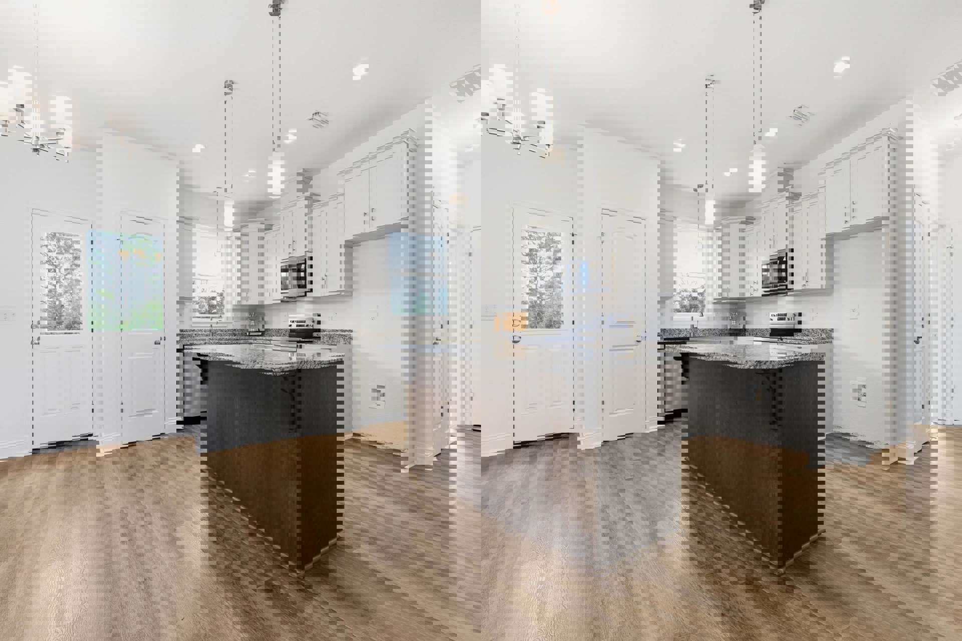 Spacious kitchen featuring a large marble-topped island, white cabinetry, stainless steel sink, glass-door microwave, and light wood flooring; white door with silver knob visible