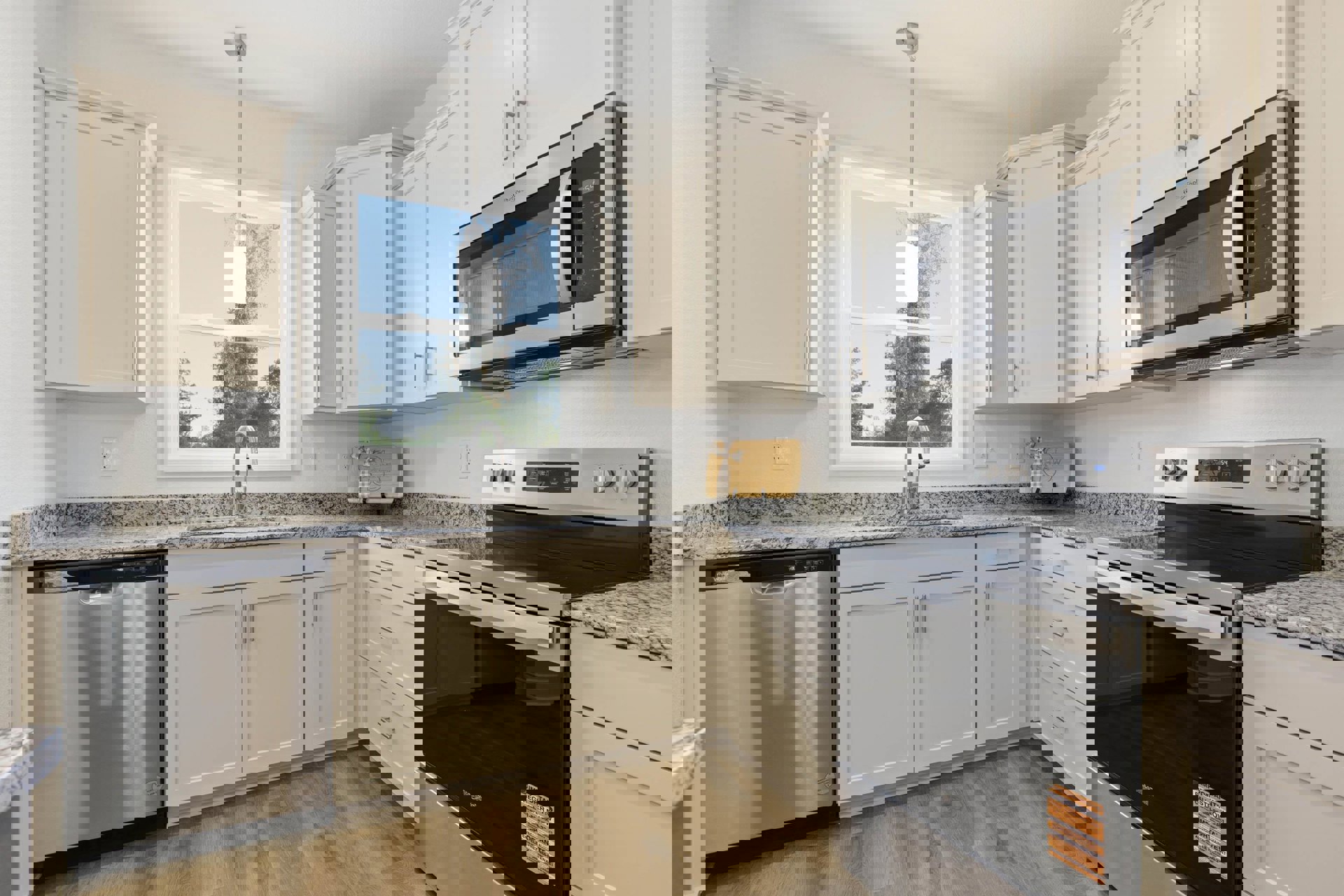 White kitchen cabinets, black appliances including stove and microwave, silver dishwasher with black handle, white door with silver handle, natural light from window illuminating