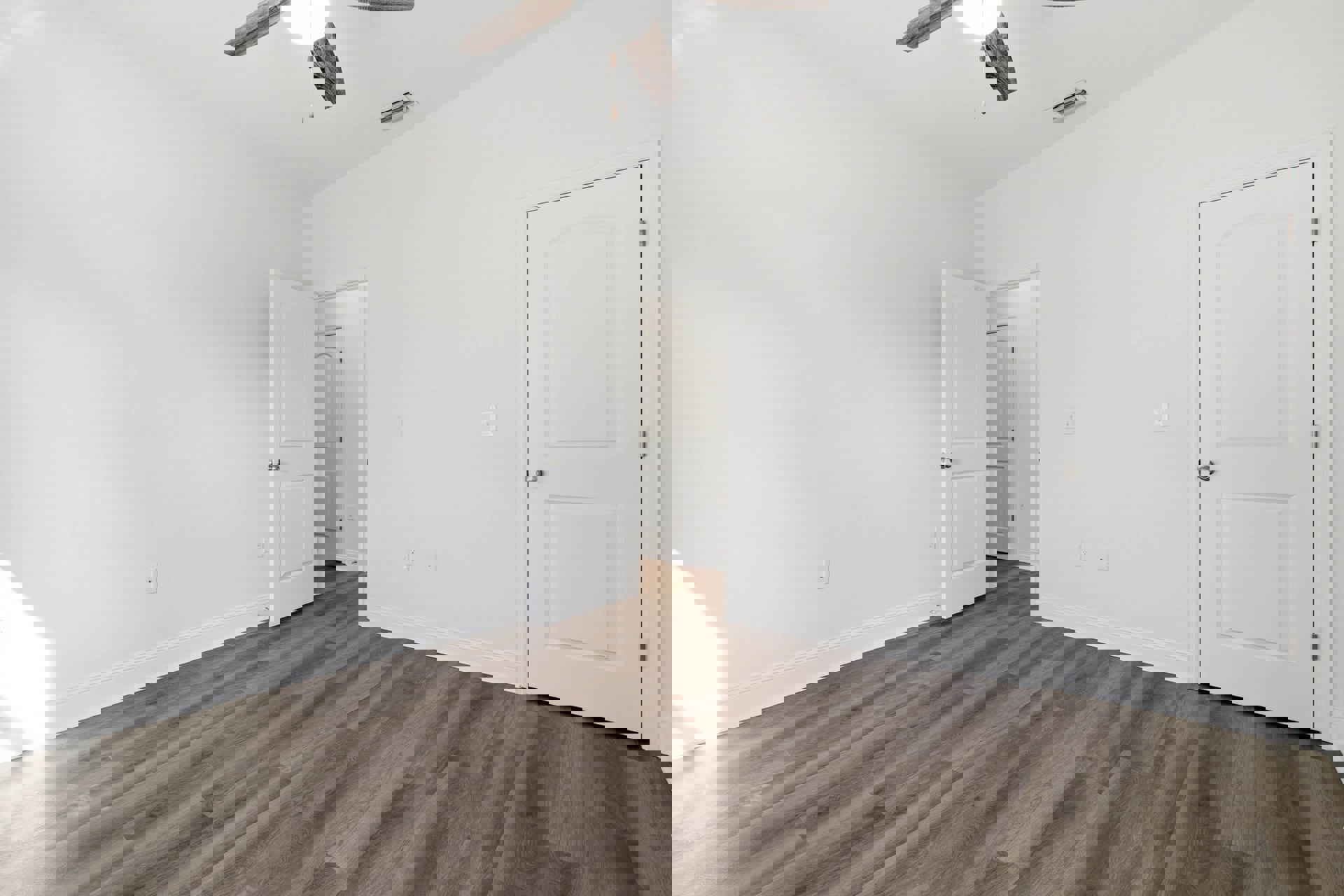 Ceiling fan mounted on white plaster ceiling, wood laminate flooring, white doors with silver knobs, neutral walls