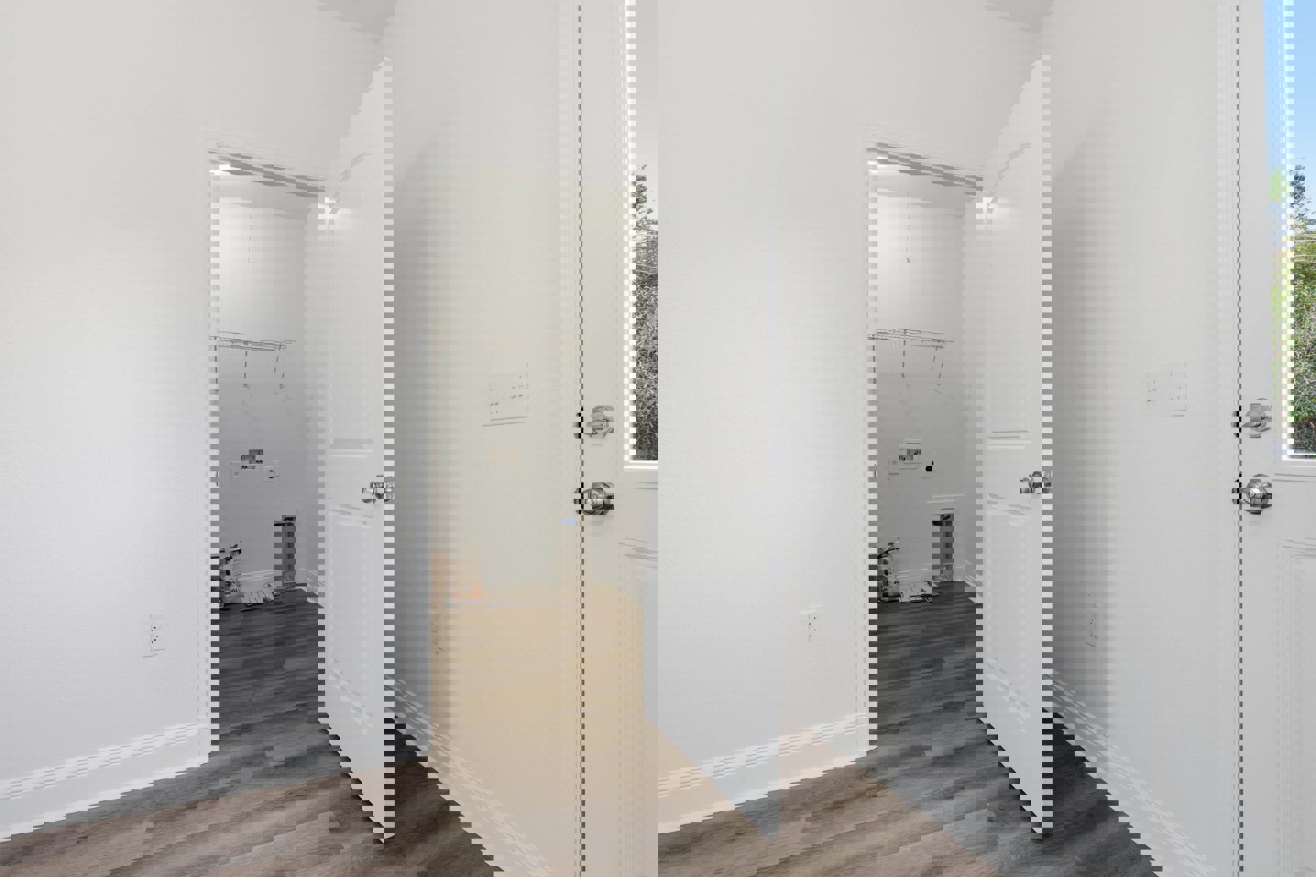 White paneled door set in a plastered wall, row of electrical switches and power outlet nearby, cement bag resting on unfinished floor, close-up window with white trim, water pump