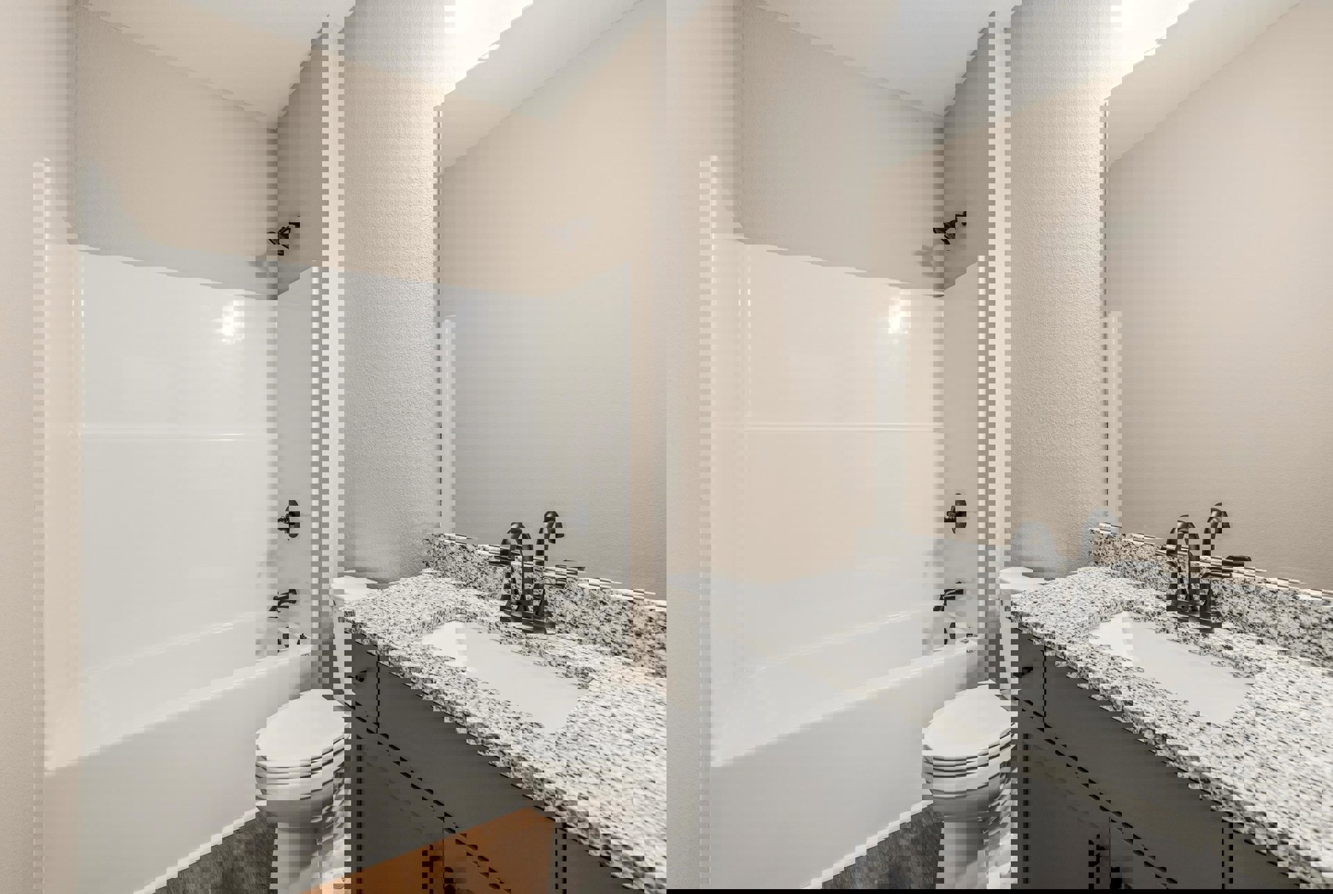 Modern bathroom featuring a freestanding white bathtub, wall-mounted sink with chrome faucet, tiled walls, glass shower enclosure, and a closed white toilet adjacent to