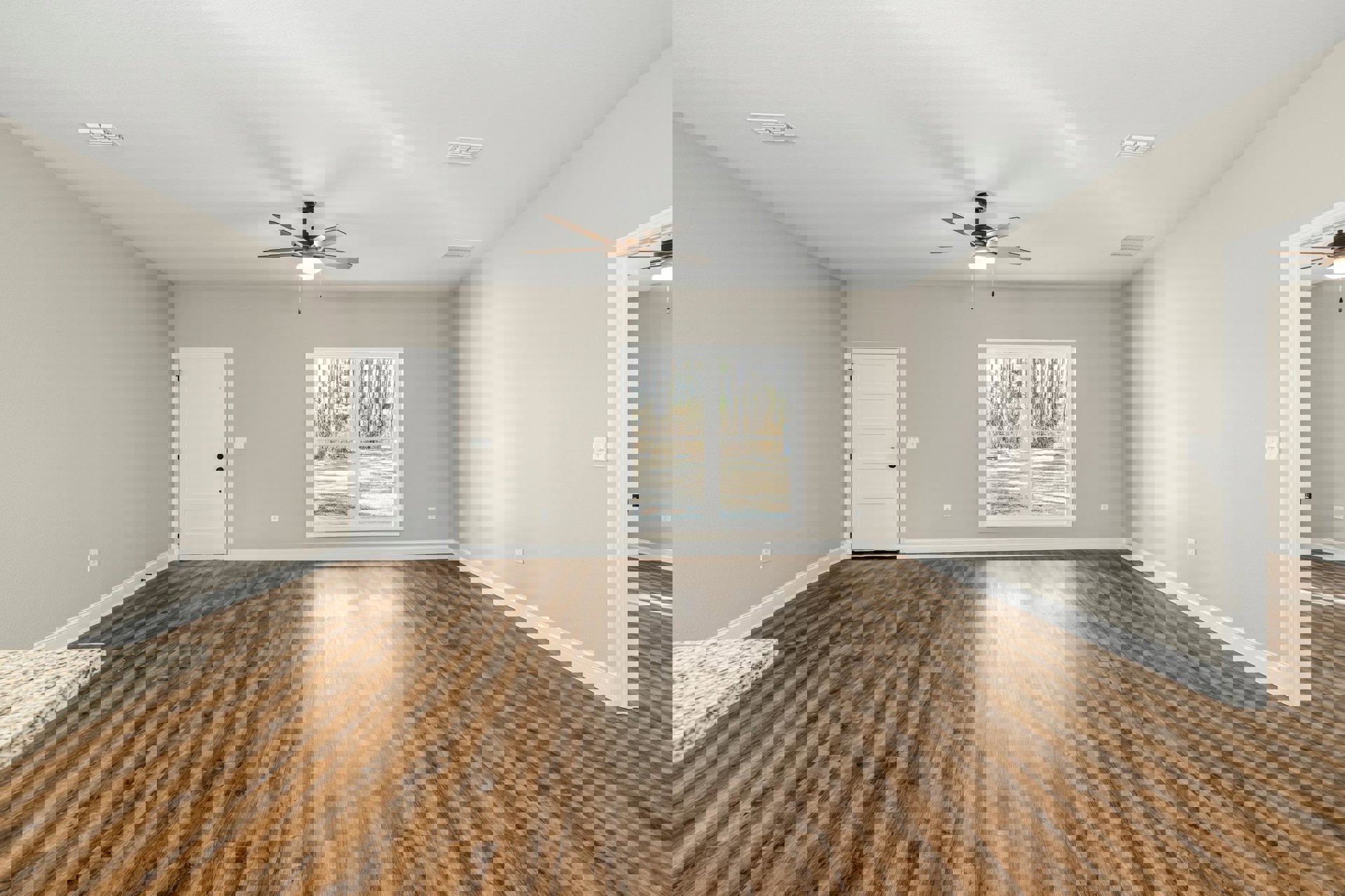 Wood flooring and white walls, ceiling fan with light, white door with black hardware, window overlooking trees, close-up of stone countertop