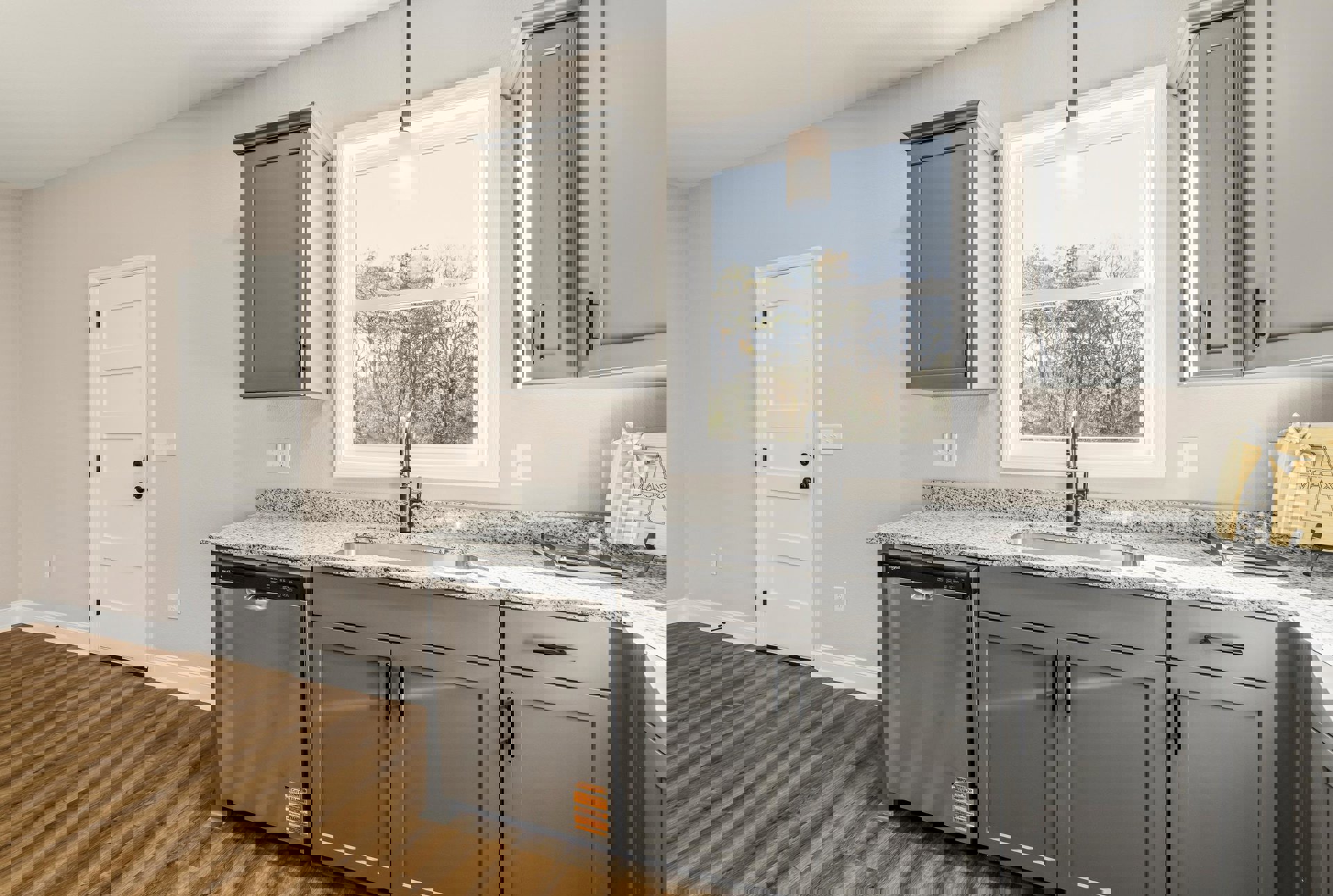 Modern kitchen featuring white cabinetry, stainless steel sink beneath a large window with views of trees, light fixture overhead, stone countertop, built-in dishwasher, and