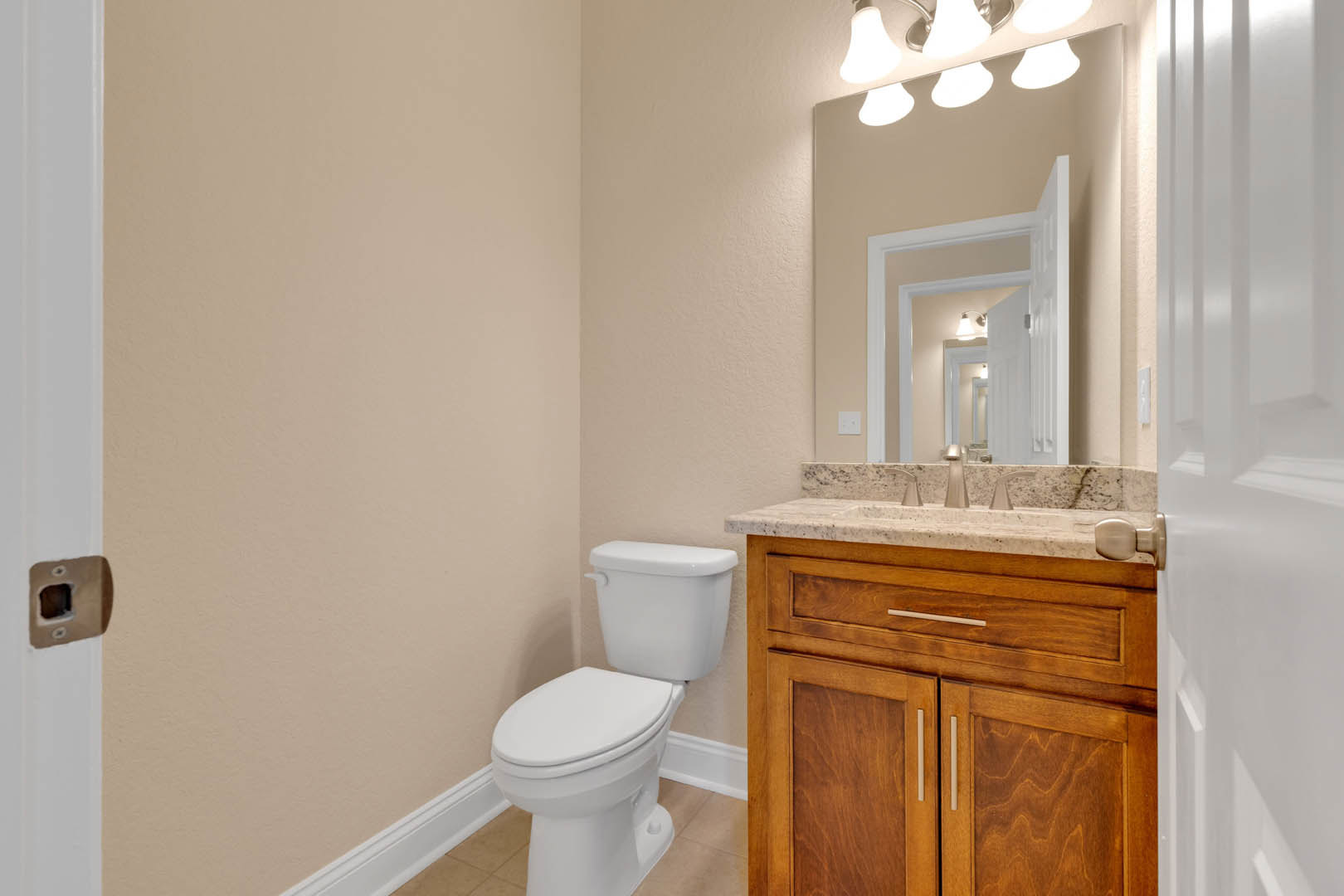 White porcelain toilet and rectangular sink with chrome faucet set against light gray tiled walls in a modern bathroom