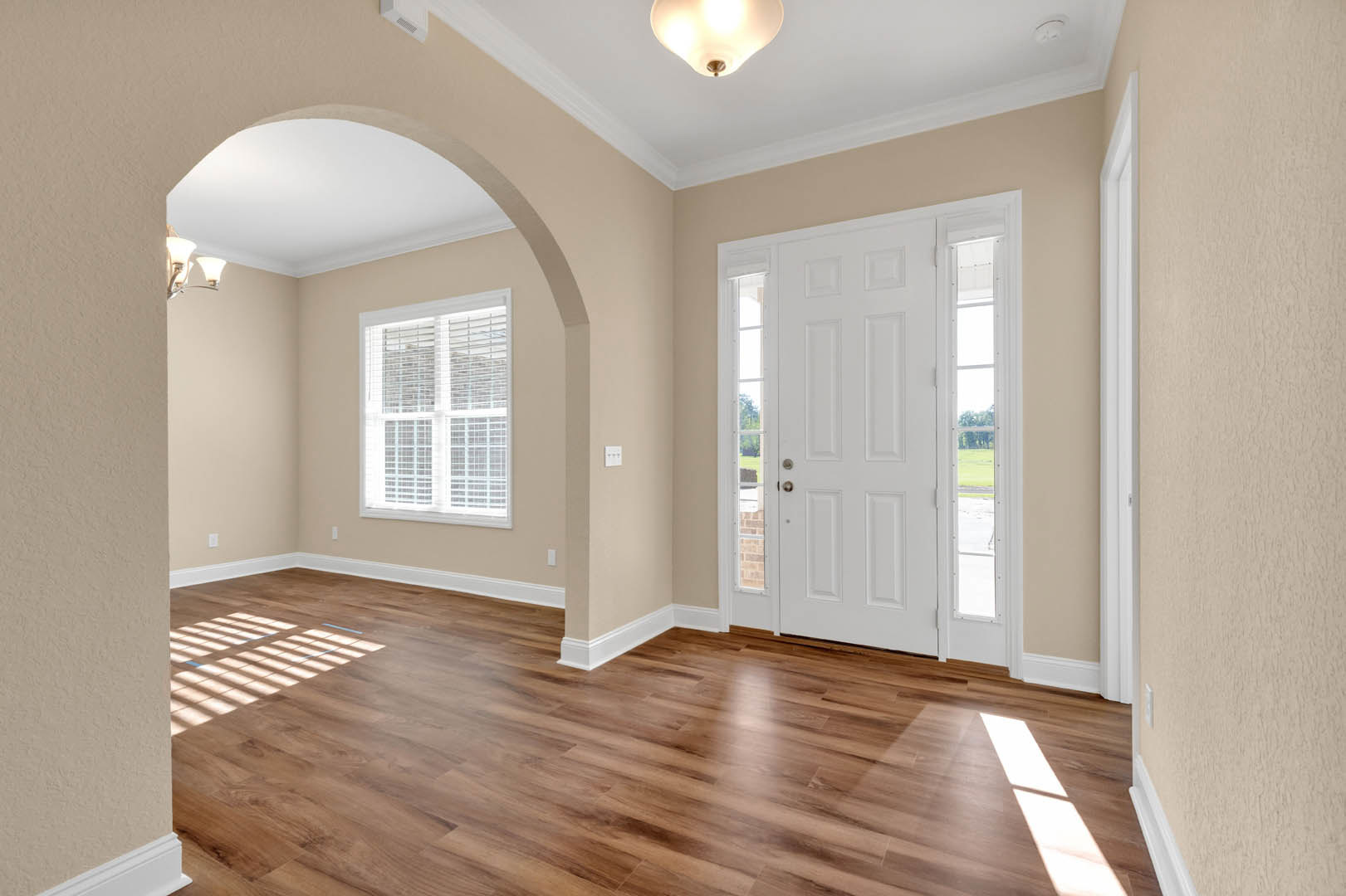 White paneled door with glass inserts, hardwood floor, white walls, ceiling with recessed lighting, decorative molding along baseboards