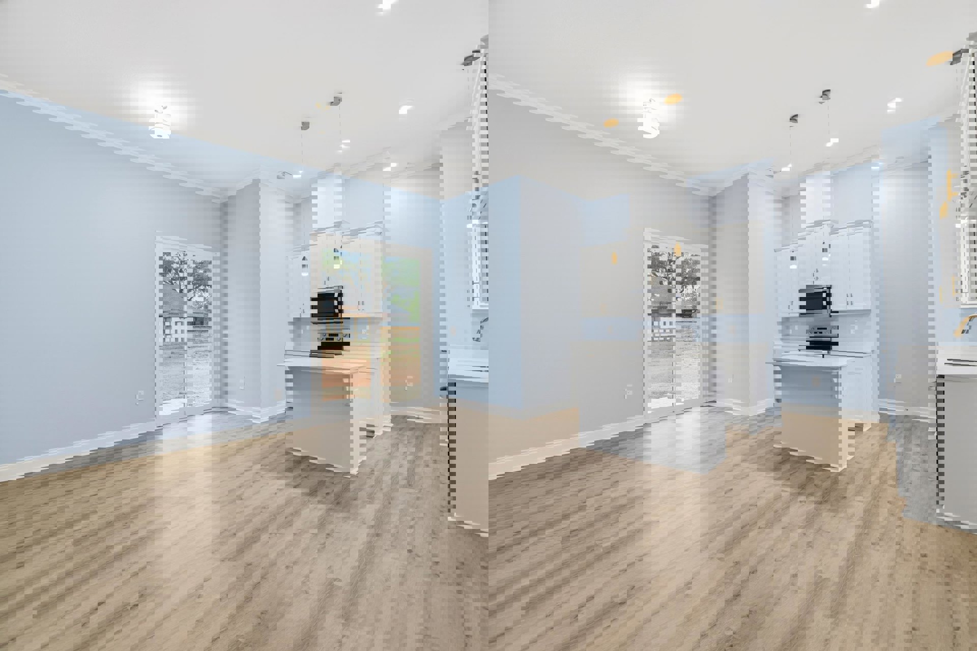 Kitchen with light wood flooring, white cabinetry, white countertops, built-in microwave, large window overlooking neighboring house, plaster walls, and recessed ceiling lighting