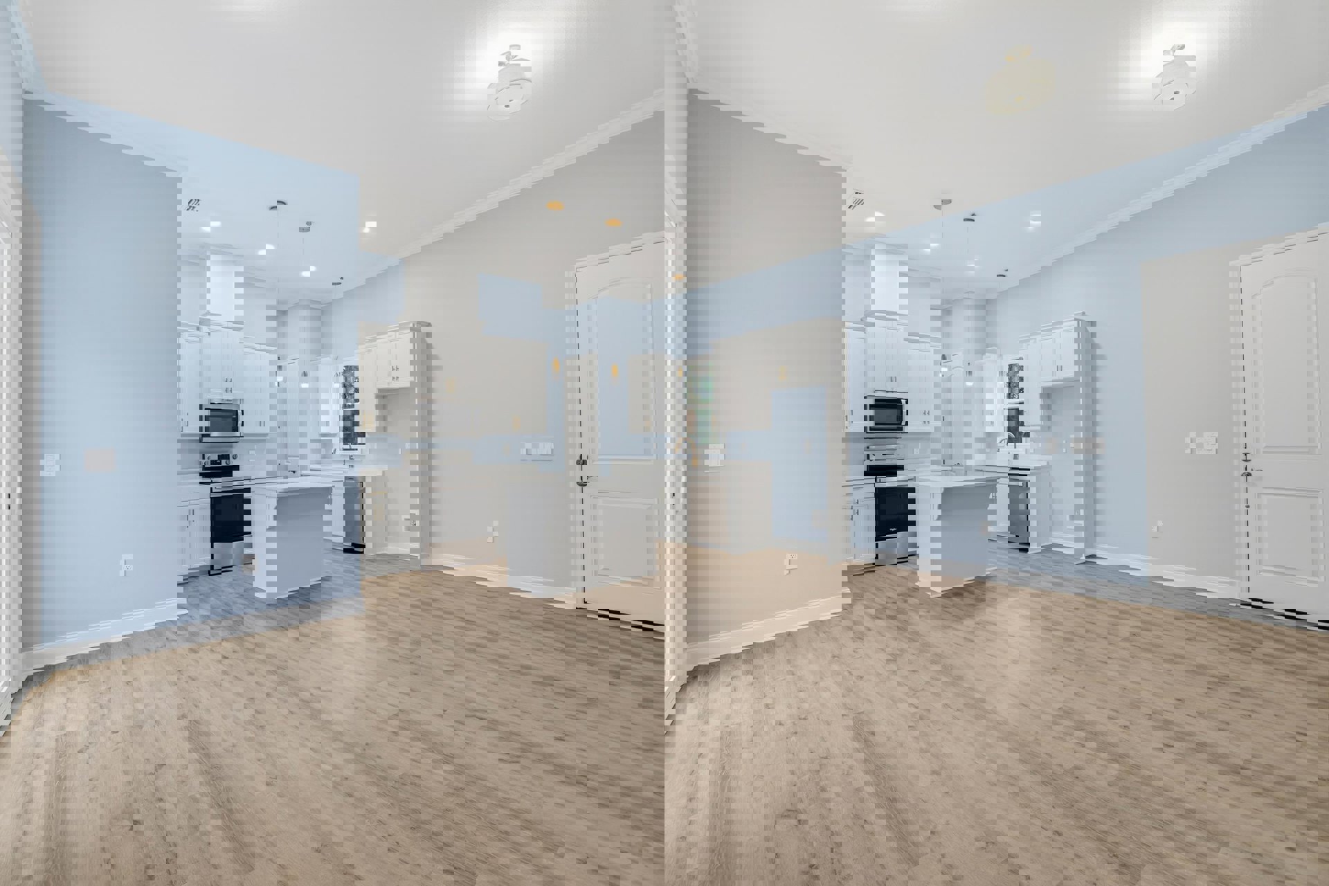 Open kitchen and dining area with wood flooring, white cabinetry, stainless steel stove and microwave, white countertop, and a white door with silver handle