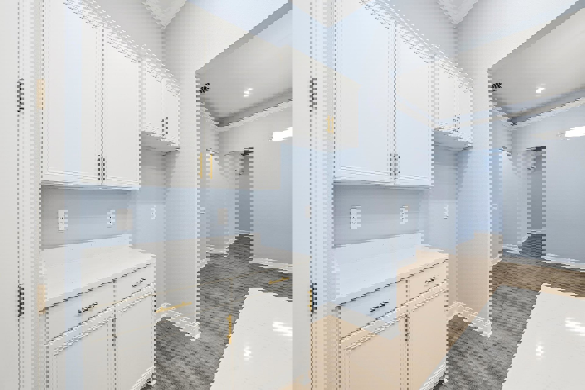 Kitchen with white shaker cabinets, gold hardware, white quartz countertop, wood plank flooring, white electrical outlet, and white door with matching trim