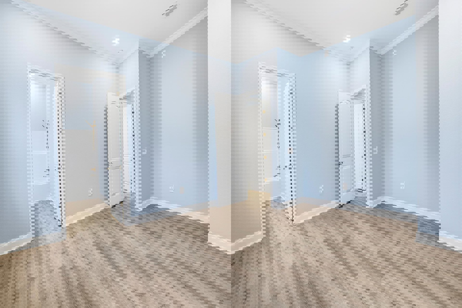 Blue-painted walls, wood plank flooring, white door with silver handle and gold hinges, plaster wall finish, laminate wood floor, indoor residential space