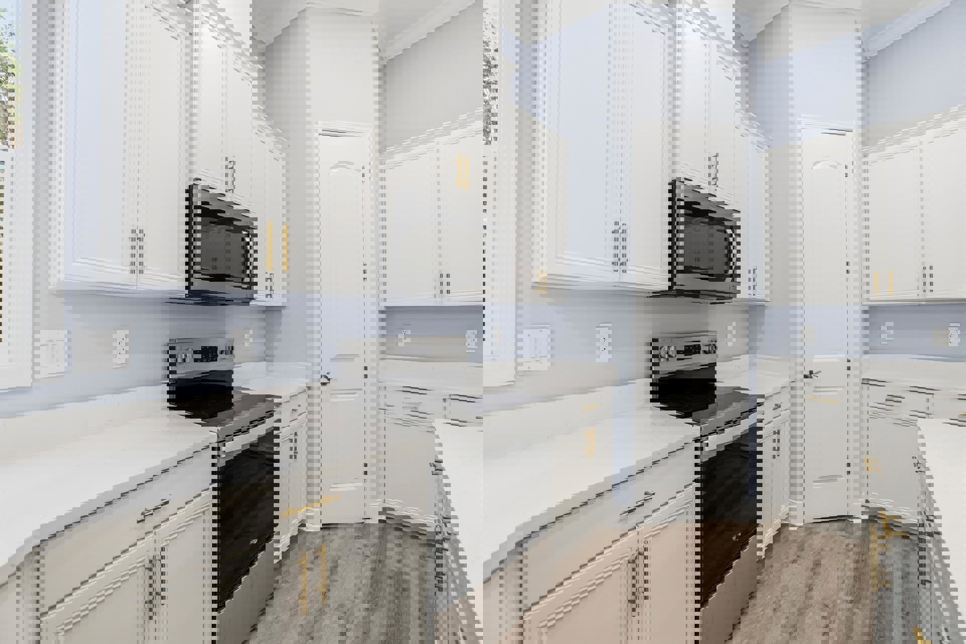 White kitchen cabinets, black stove and microwave, white electrical outlet, white door with silver doorknob, light countertops