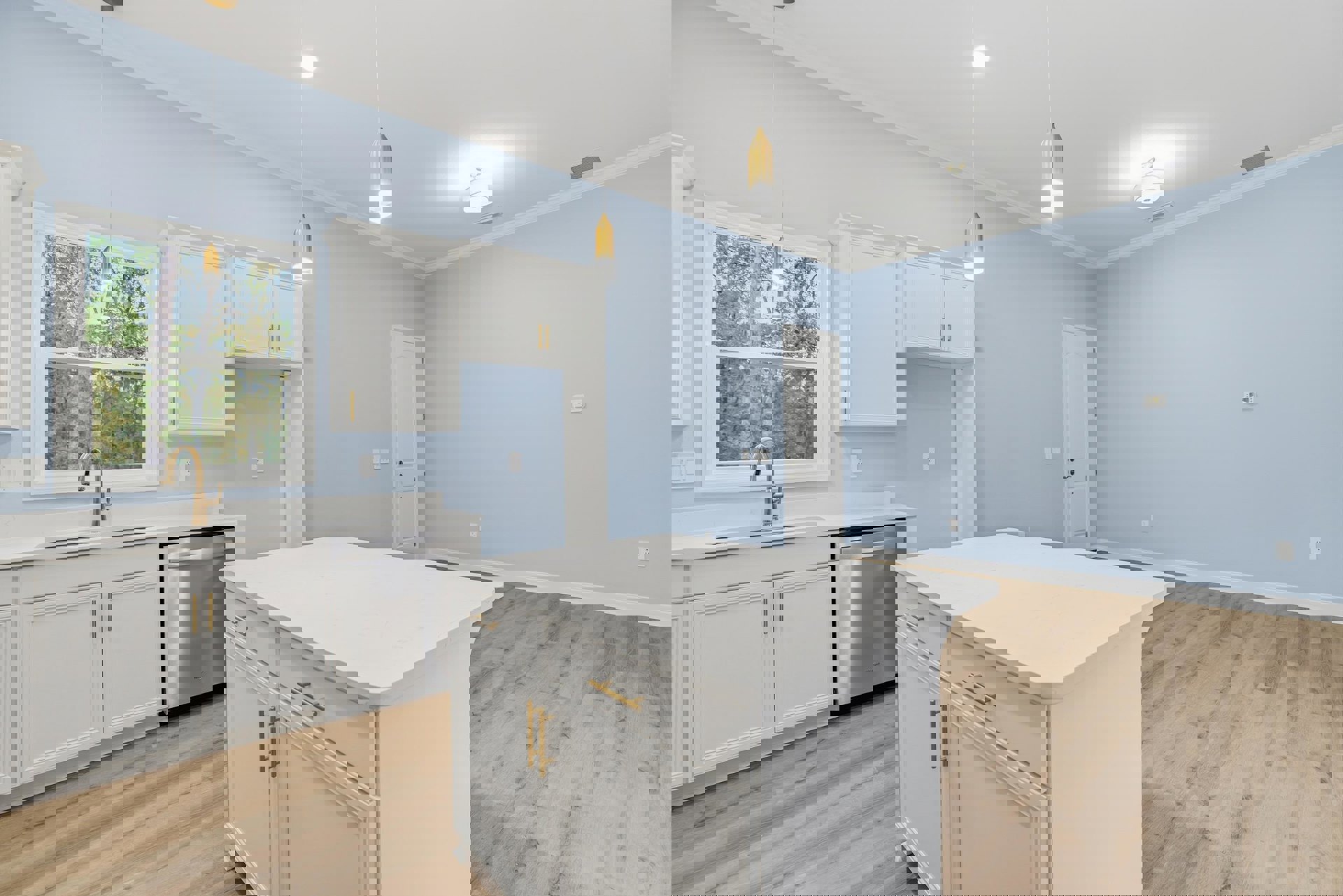 White kitchen island with gold handles, wood flooring, white cabinetry, window above sink with white light fixture, built-in dishwasher, white door with gold handle