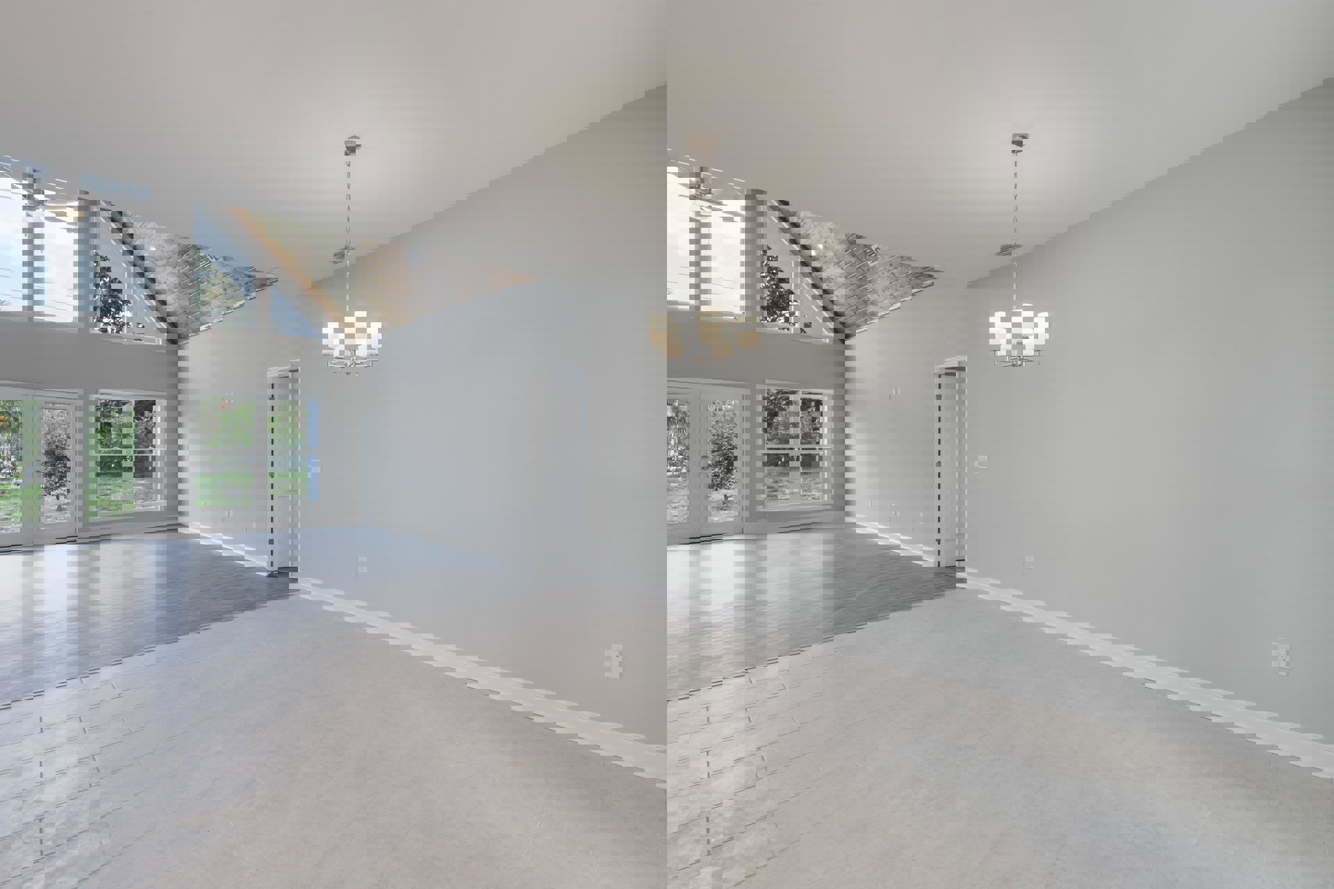 White tile floor with gray accents, white plaster walls, ceiling with a chain-hung chandelier, black-handled door, large window, modern interior finishes