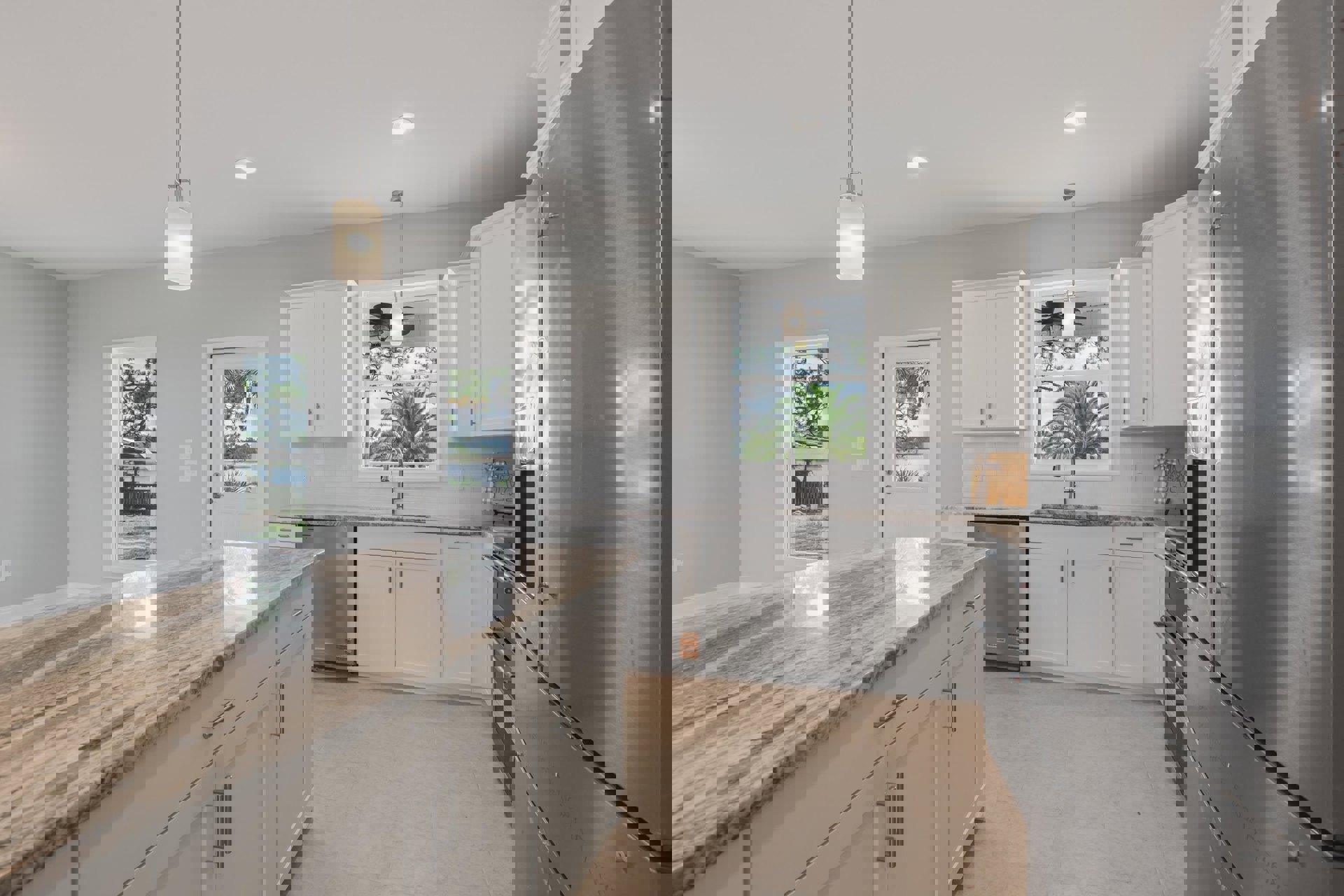 White kitchen cabinets with silver handles, granite countertops, stainless steel refrigerator, under-cabinet lighting, palm tree visible through window