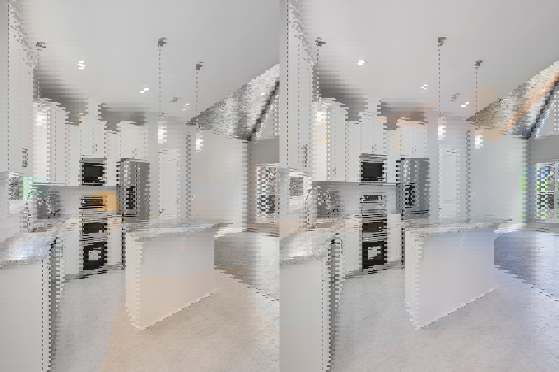 White kitchen with shaker cabinets, marble island countertop, stainless steel oven and refrigerator, undermount sink, and large window with white trim