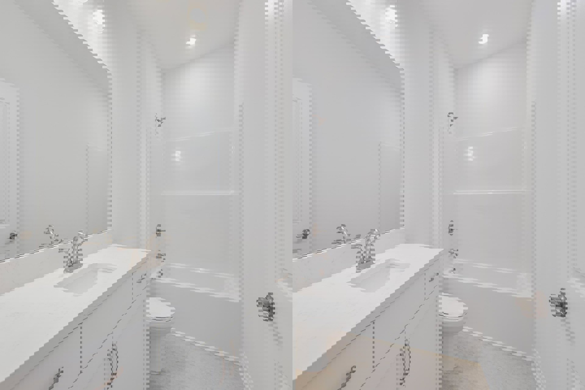 Modern bathroom with white tile walls, built-in bathtub, single sink vanity with chrome faucet, wall-mounted mirror, and closed toilet adjacent to a tiled corner