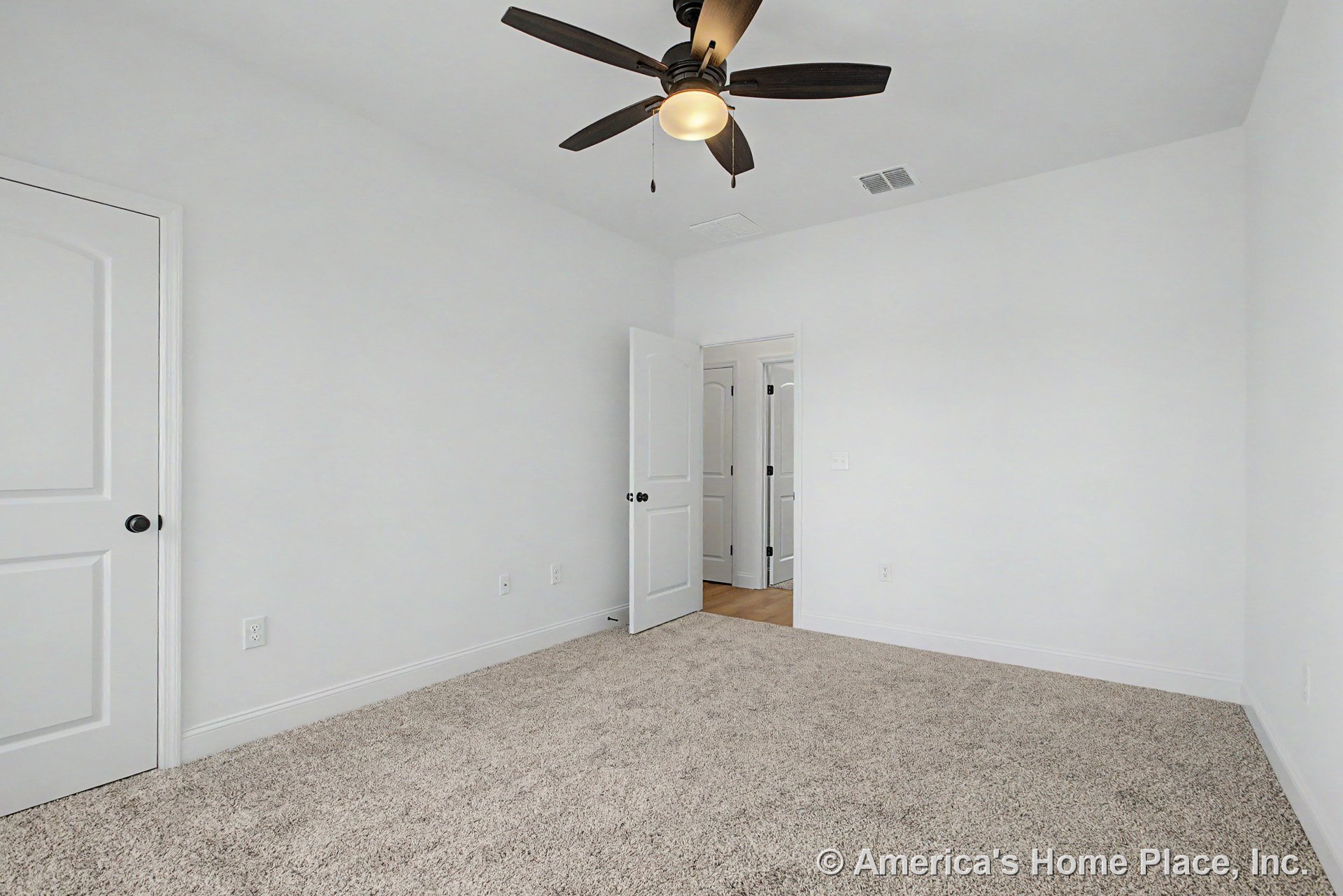 Bedroom with light carpet flooring, white paneled doors, ceiling fan with integrated light, white baseboards, neutral wall color, and standard electrical outlets.