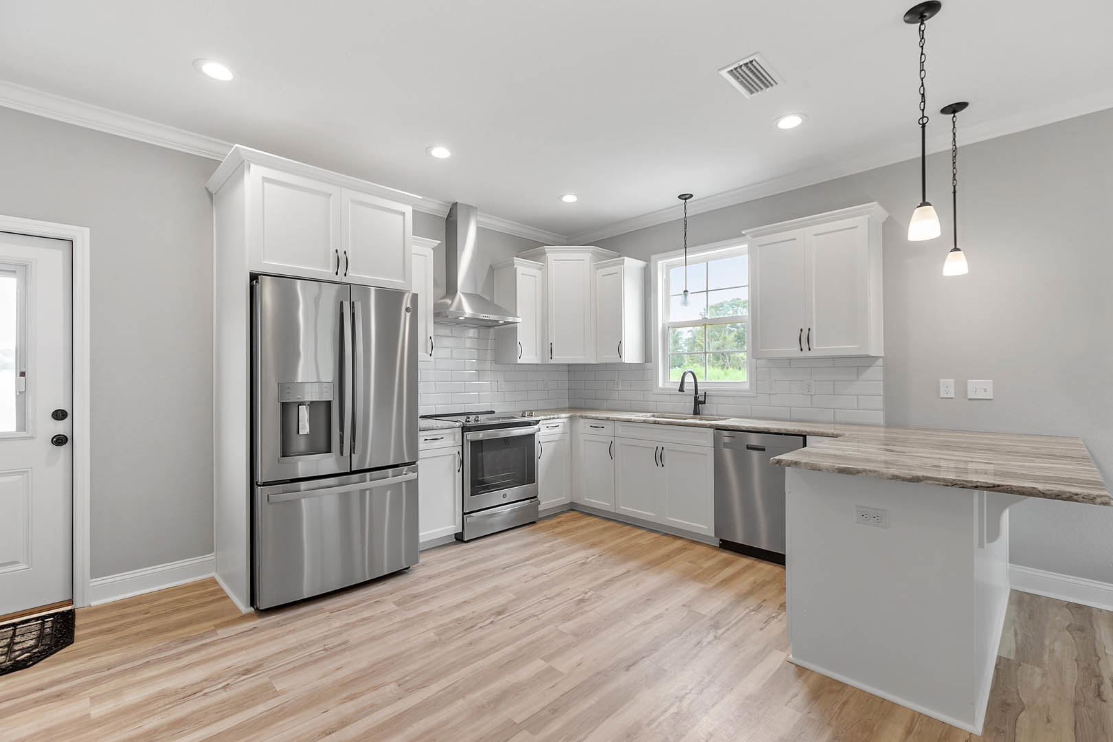 Kitchen featuring stainless steel refrigerator with water dispenser, stainless steel stove, hardwood flooring, white cabinetry, stone countertop, and modern chandelier above the