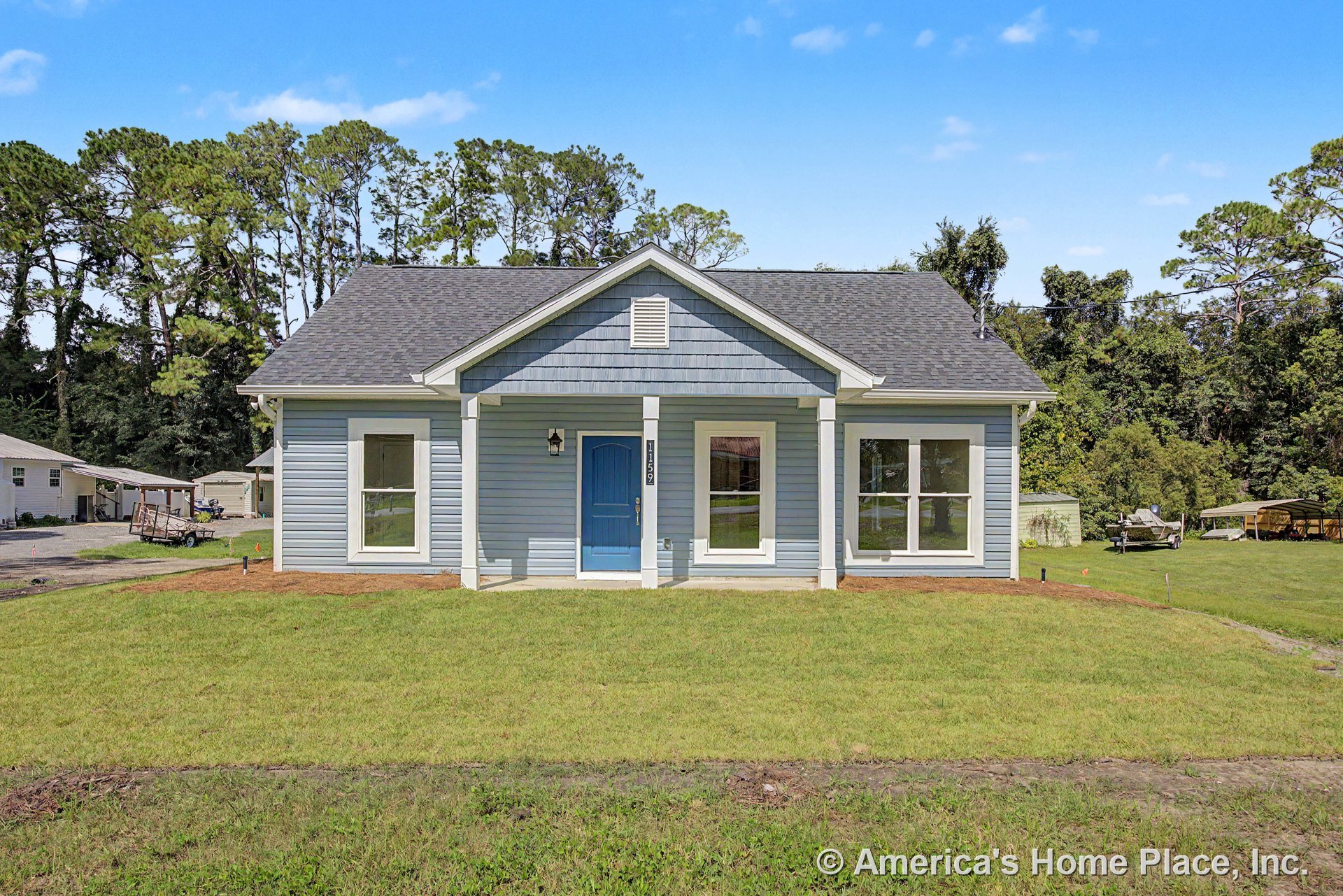 Blue siding exterior with white trim, covered front porch supported by columns, large front windows, gable roof, and front entry door on a single-story residential home.
