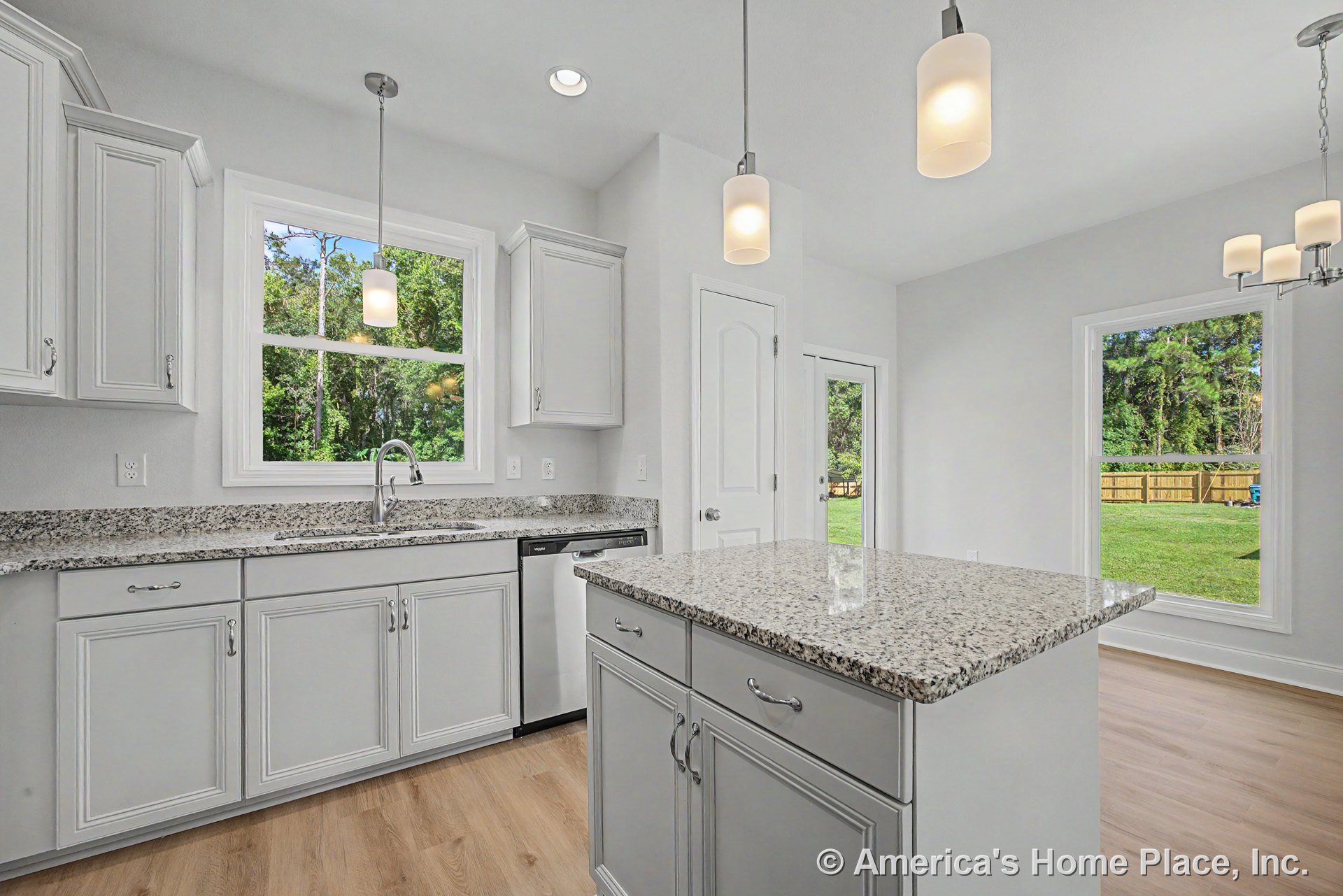 Light gray shaker cabinets, granite island countertop, stainless steel dishwasher, wood-look flooring, recessed and pendant lighting, large double hung windows with white trim