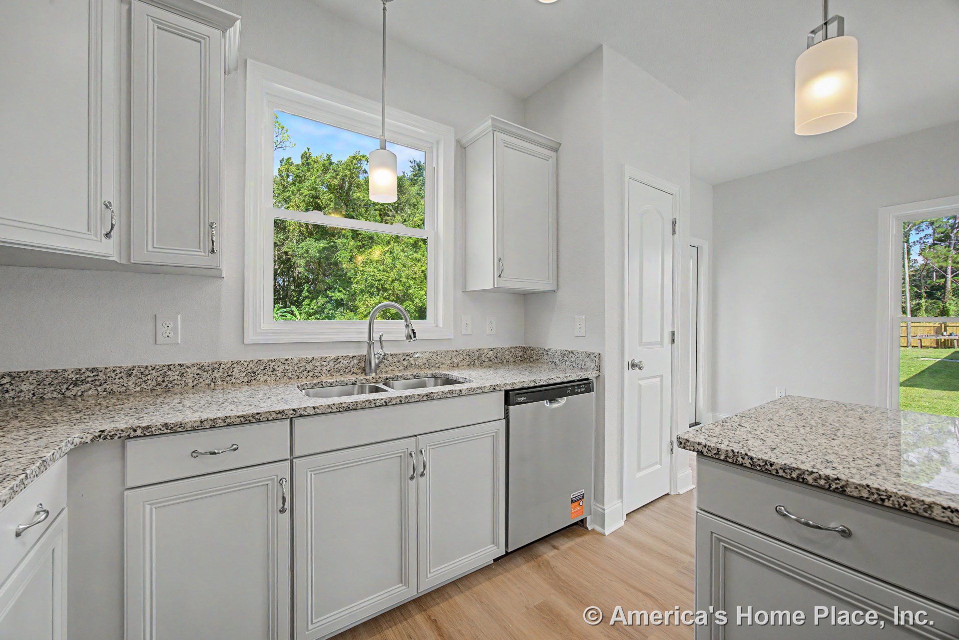 Granite countertops with white shaker cabinets, stainless steel dishwasher and appliances, double bowl sink with modern faucet, pendant lights above, wood-look flooring, large