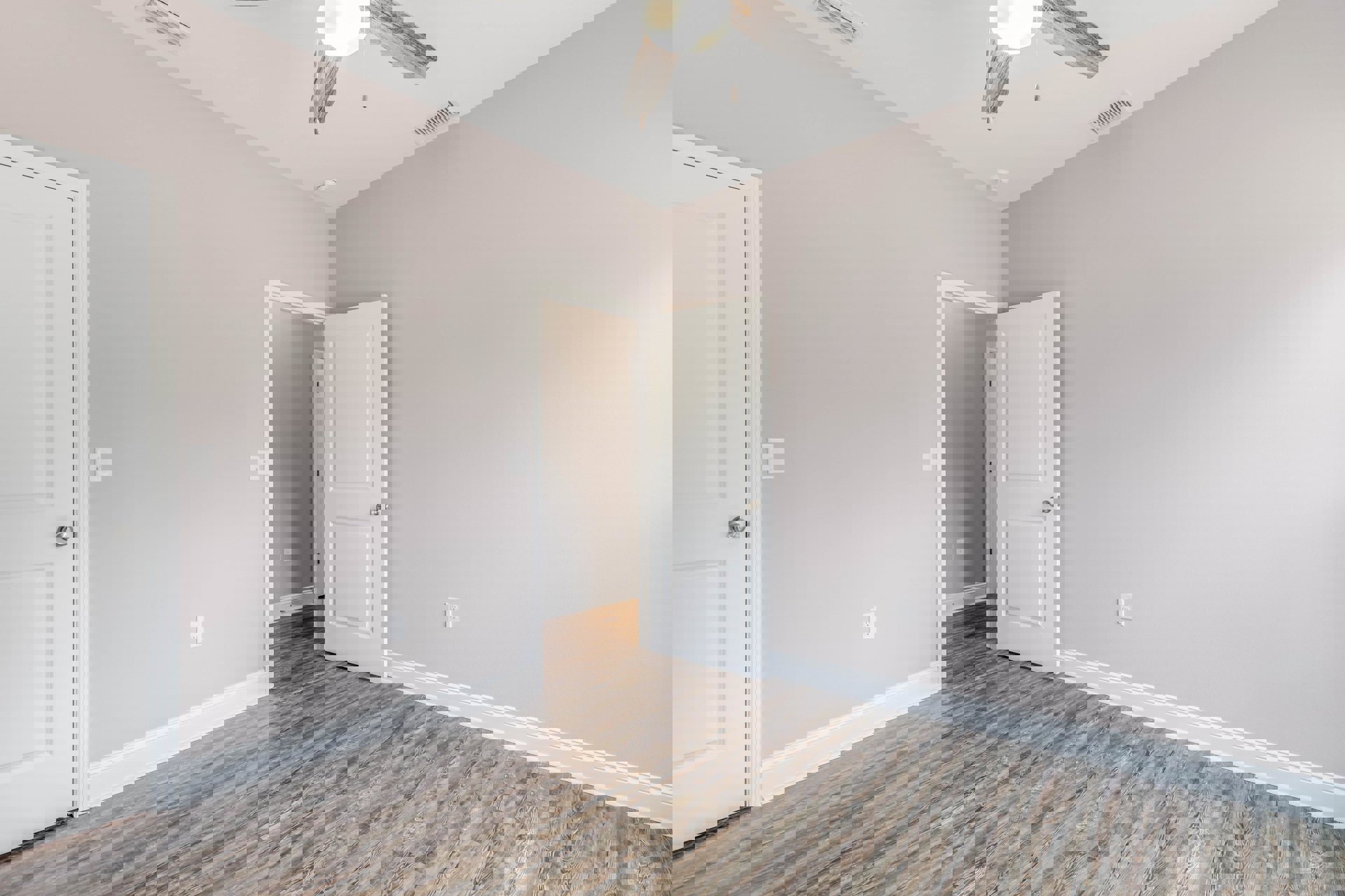 Room with wood laminate flooring, white walls, white paneled door with silver knob, ceiling fan with light fixture, crown molding along ceiling.