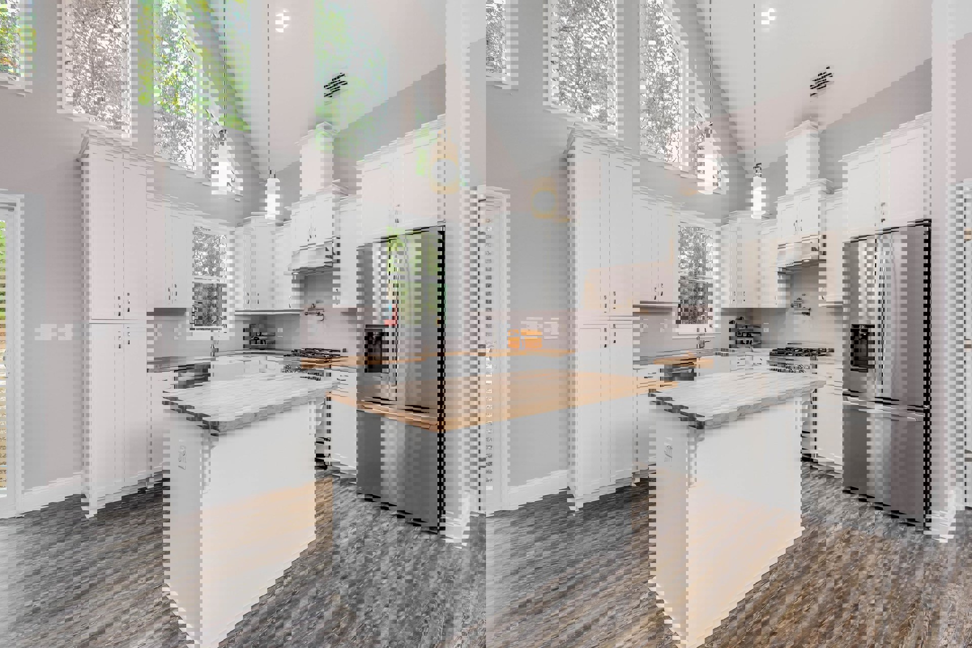 White shaker cabinets, stainless refrigerator, wood flooring, quartz countertops, tile backsplash, pendant light fixture, undermount sink, wall vent