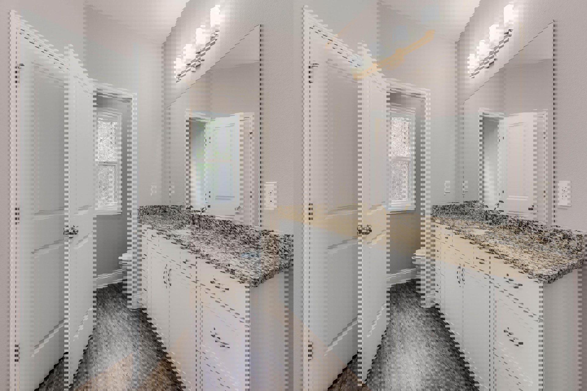 Bathroom with marble countertop, undermount sink, white toilet, tile flooring, window overlooking trees, white wall with electrical outlet, round light fixture on ceiling