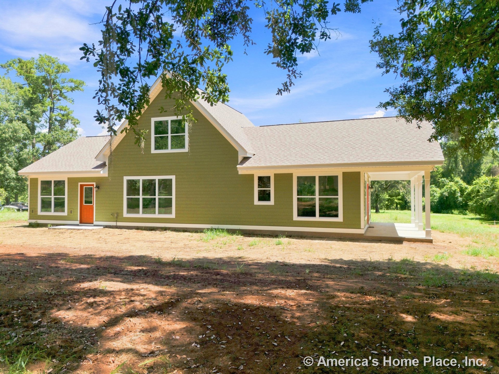 Green horizontal siding with white trim, large windows, orange front door, gable roof, and a covered side porch.