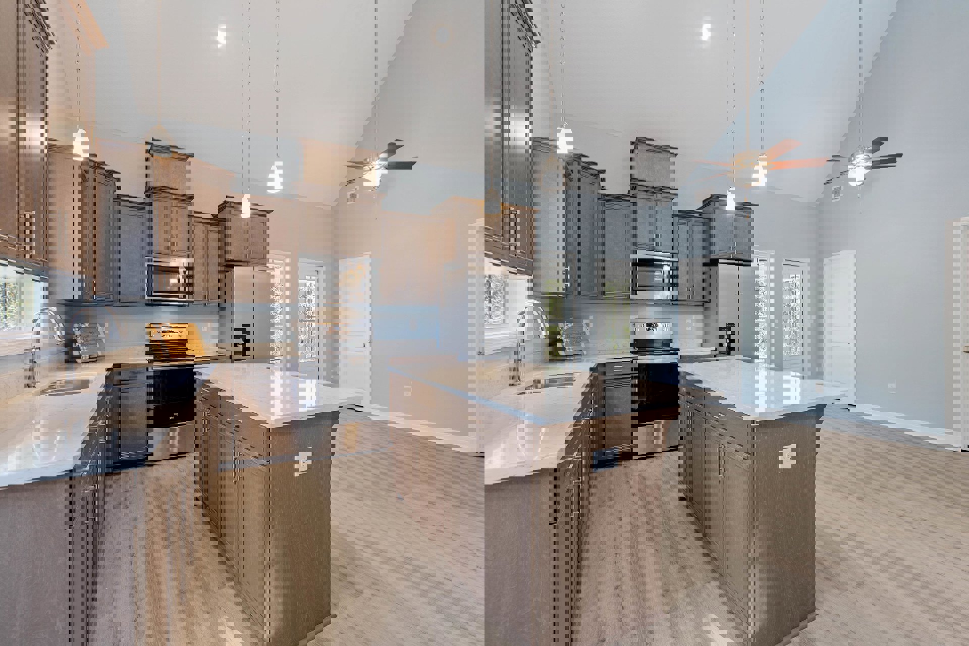 Kitchen with marble-topped island, ceiling fan, stainless steel stove with glass door, built-in microwave, white wall outlet, recessed lighting, white cabinetry, and light wood