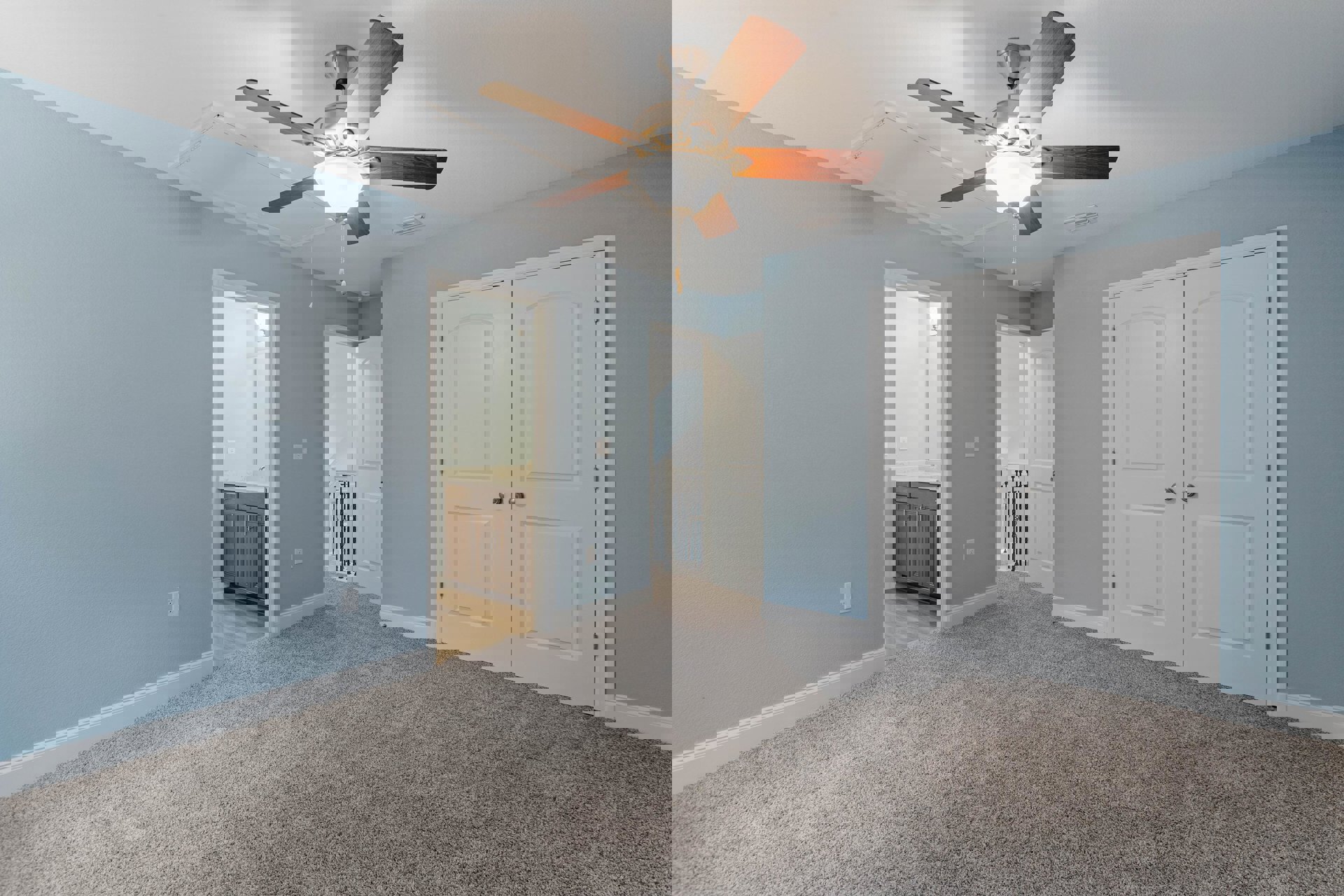 Carpeted room with white double doors, ceiling fan with light fixture, neutral walls, and plaster ceiling