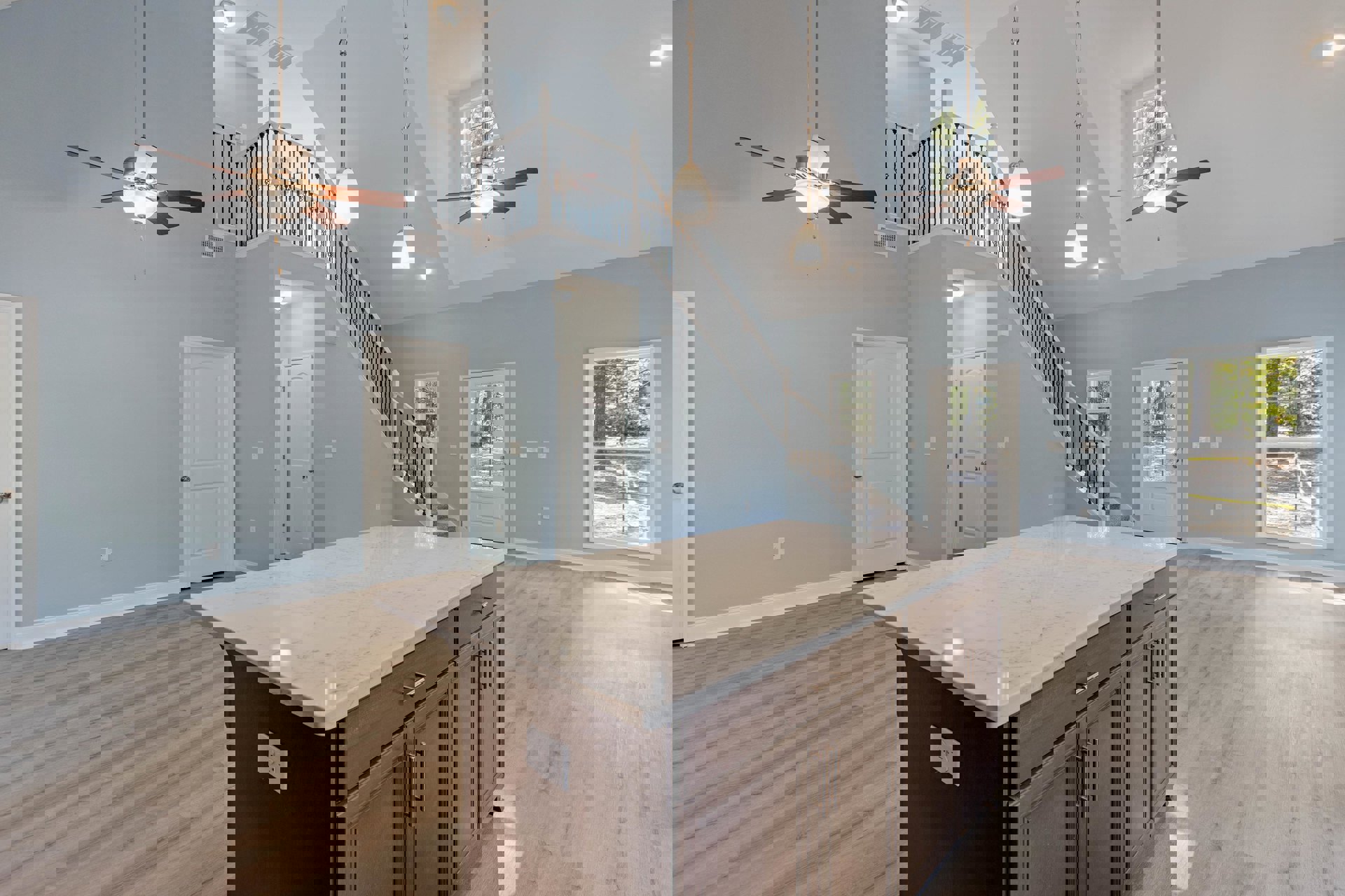 Marble-topped kitchen island with white cabinetry, stainless steel appliances, wood flooring, large window with yellow tape, and white door featuring silver knobs and window panel