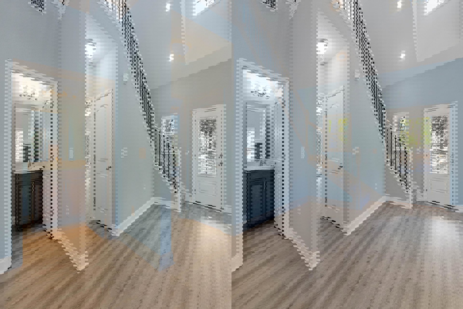 Blue-painted walls and wood staircase, white door with window and silver knob, marble countertop sink, ceiling light fixture, bathroom with mirror and sink, laminate and wood