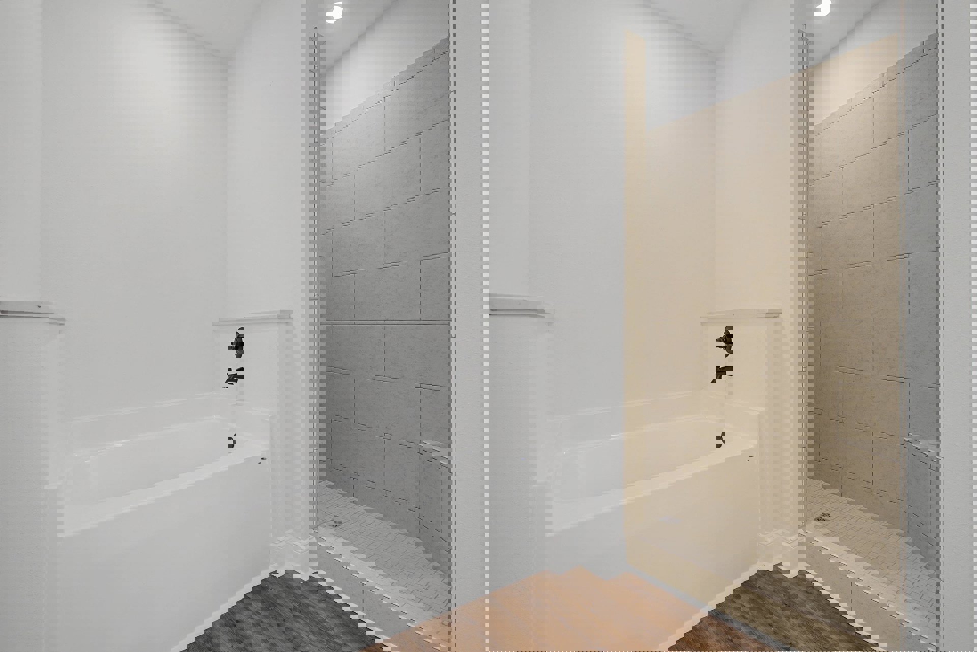 Bathroom featuring a white freestanding bathtub on brown tile flooring, glass-enclosed shower with tiled walls, chrome faucet, and recessed ceiling lighting
