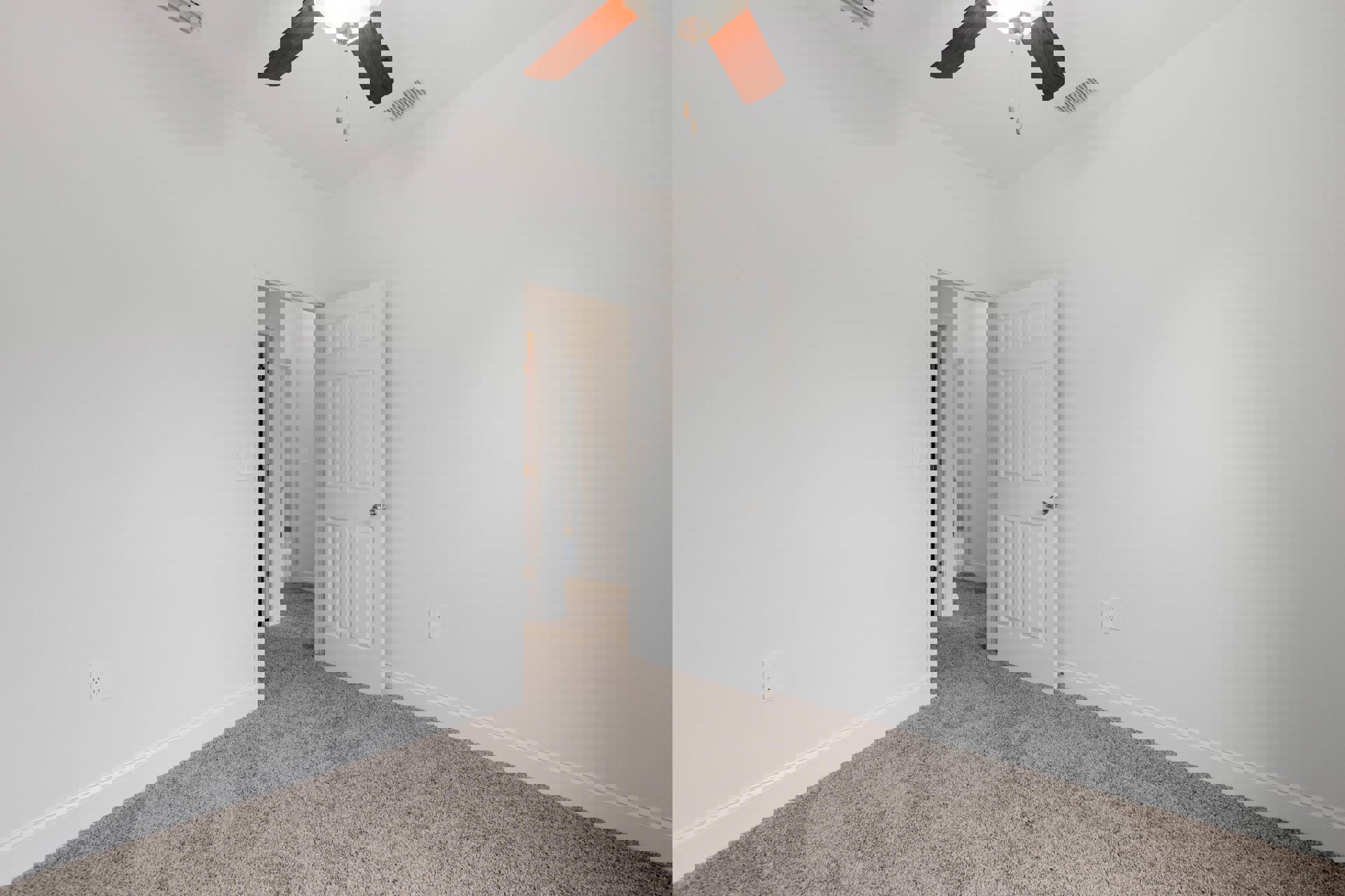 Neutral-toned room with white walls, carpet flooring, ceiling fan with light fixture, white door featuring silver knob, and visible electrical outlets.