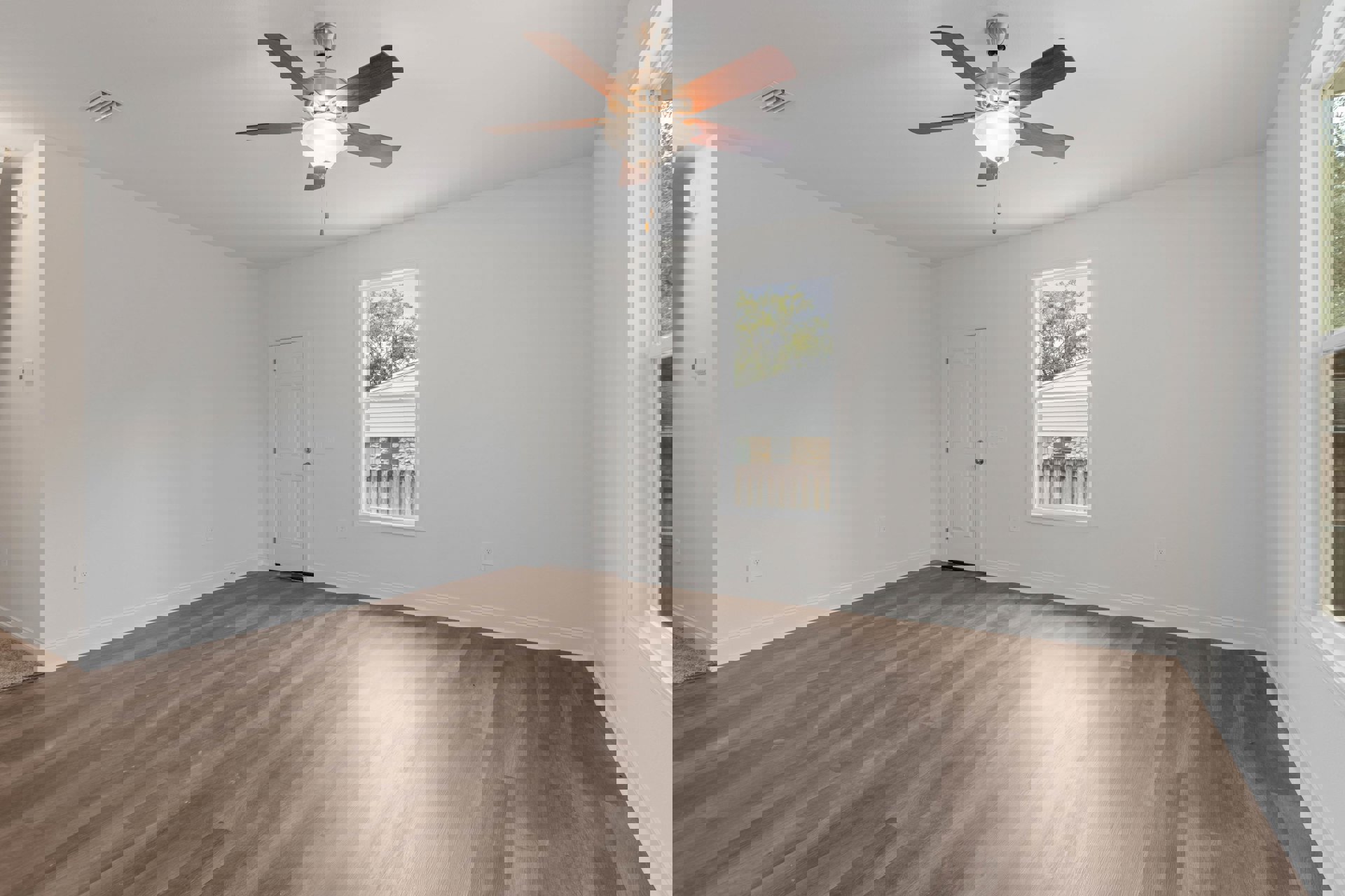 Ceiling fan with light fixture centered above wood flooring, white walls, white door with silver knobs, and window framed by white trim