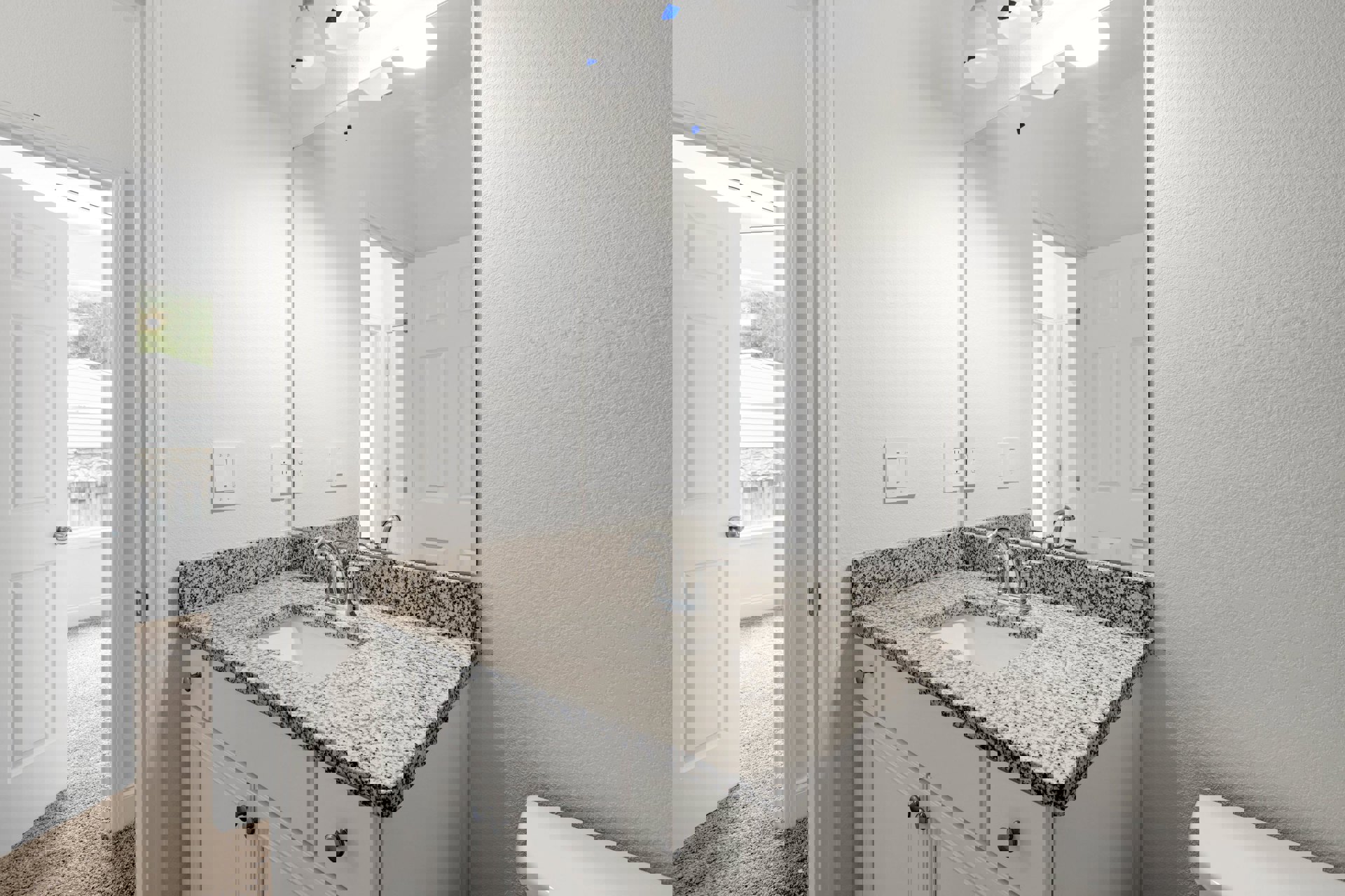 Marble countertop with undermount sink, chrome faucet, large framed mirror, white tile backsplash, and light switch on painted wall