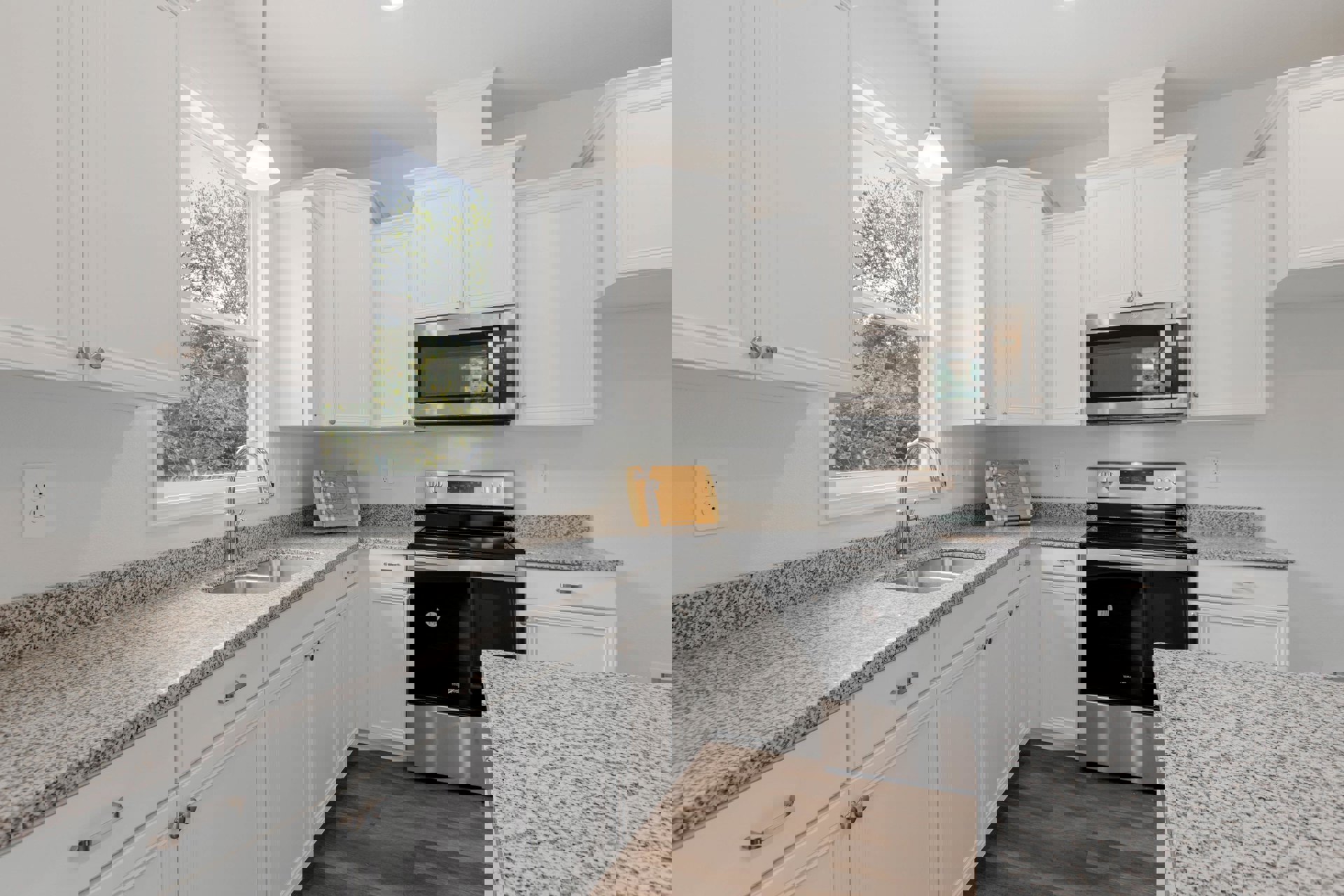 Granite countertops, white shaker cabinets, stainless steel appliances, undermount sink, and a built-in microwave in a modern kitchen