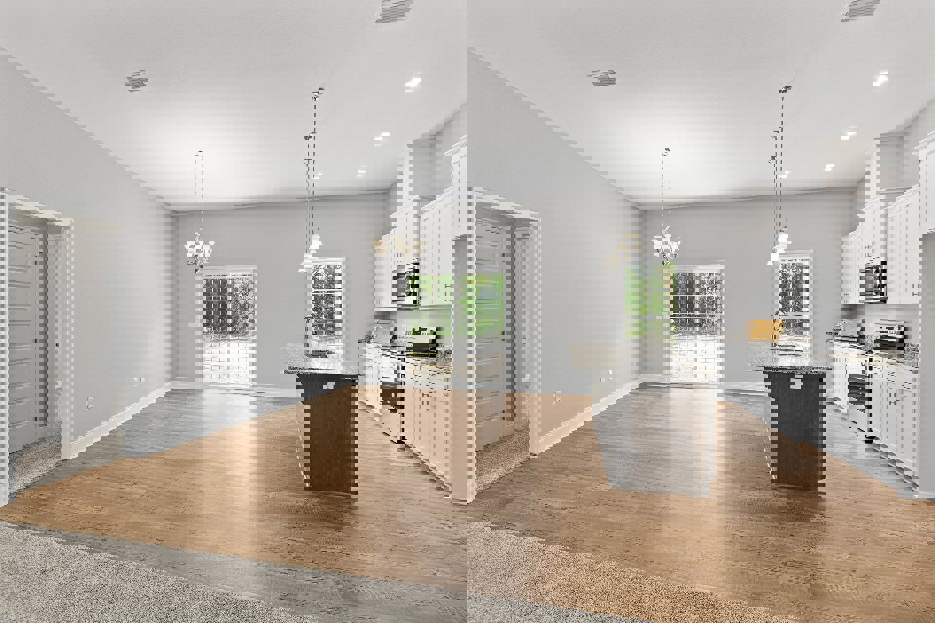 Open-concept kitchen and living room featuring hardwood floors, white sliding glass door, kitchen island with sink, open microwave oven, white interior door, and modern cabinetry