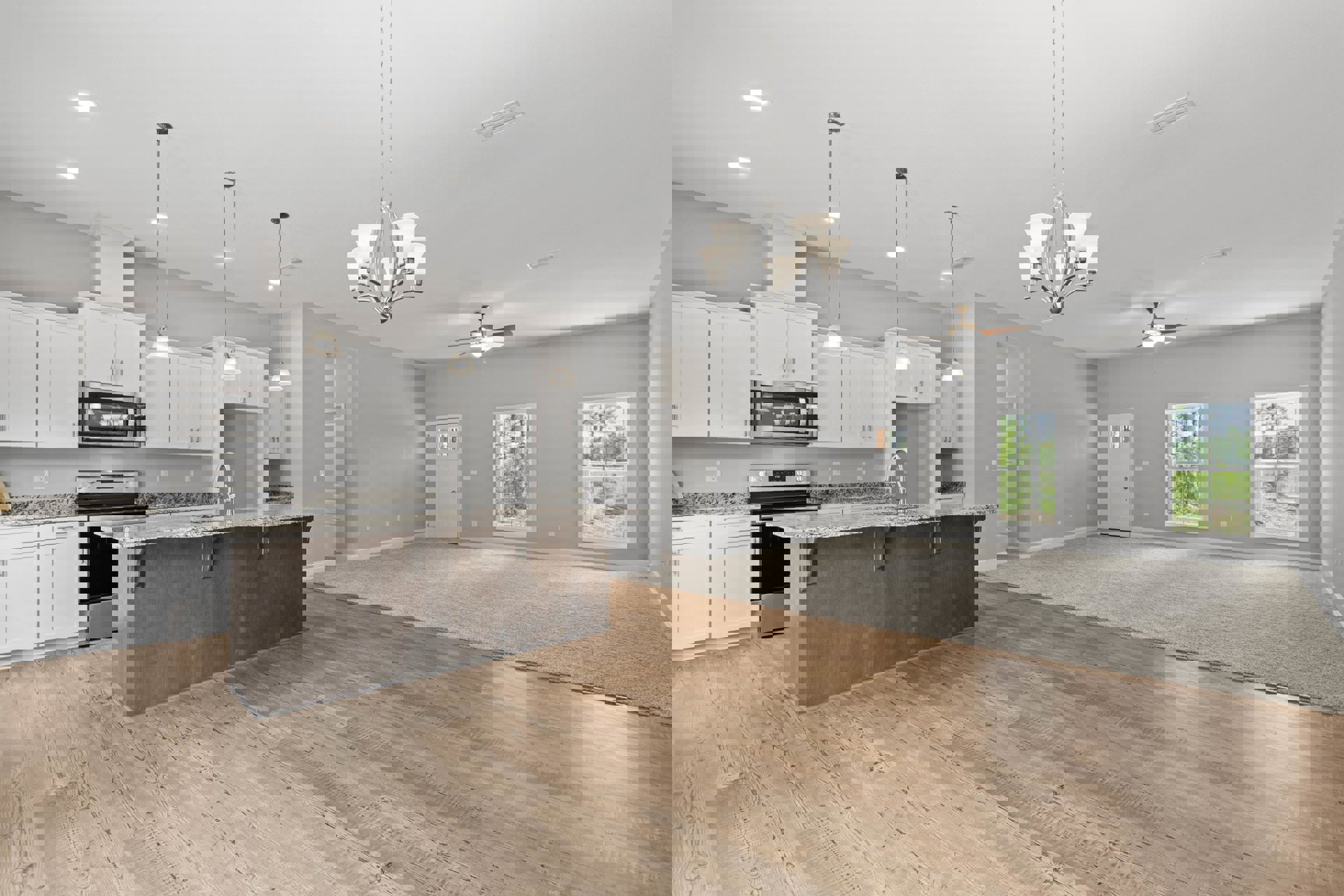 Open-concept kitchen and living room featuring wood flooring, white cabinetry, stone countertop with stainless steel faucet, pendant kitchen light, large windows showcasing tree