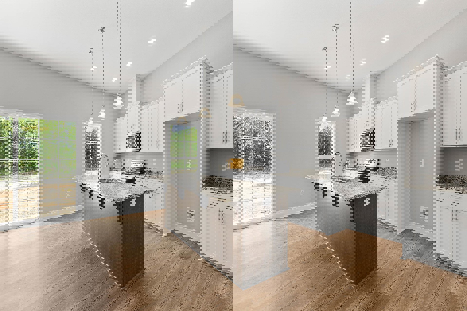 Kitchen with marble island, wood flooring, white cabinetry, stainless steel microwave, large window overlooking forest, and silver-handled door
